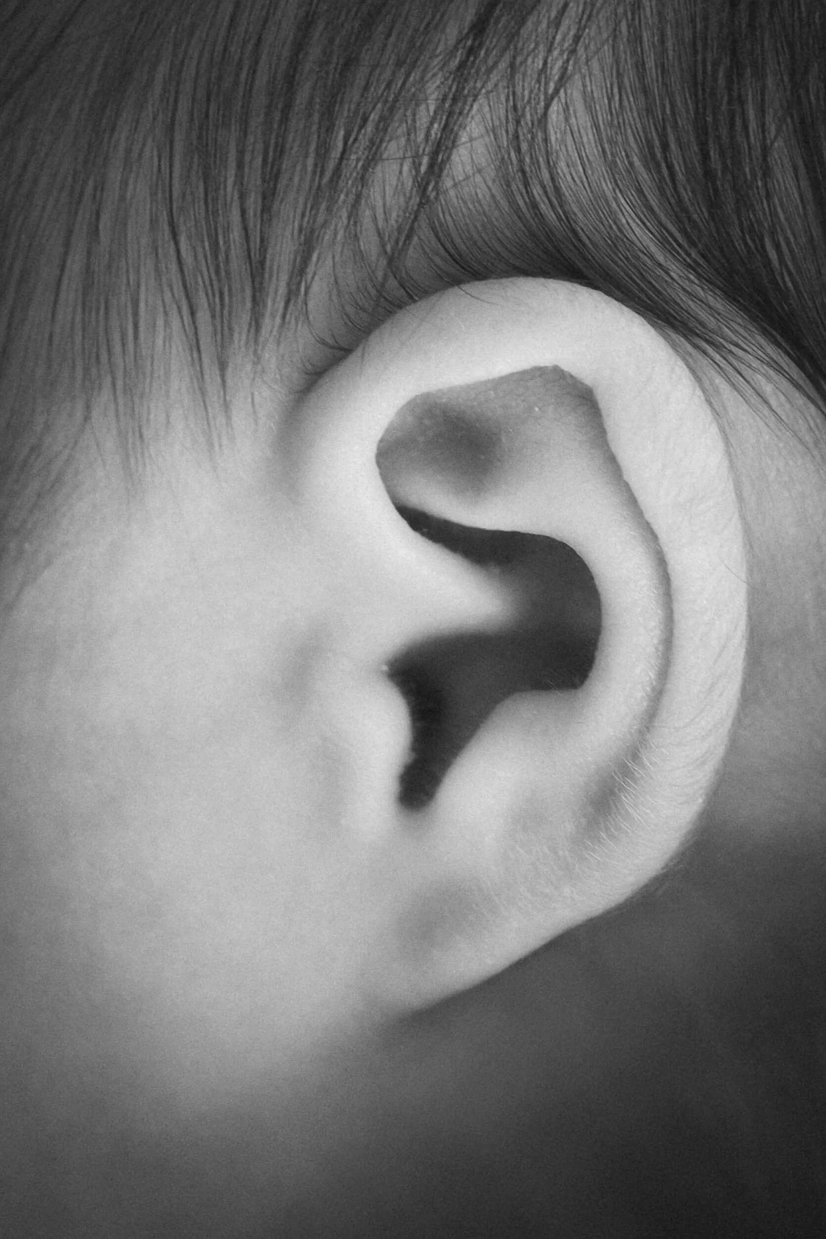 Nahaufnahme eines menschlichen Ohrs in Schwarz-Weiß