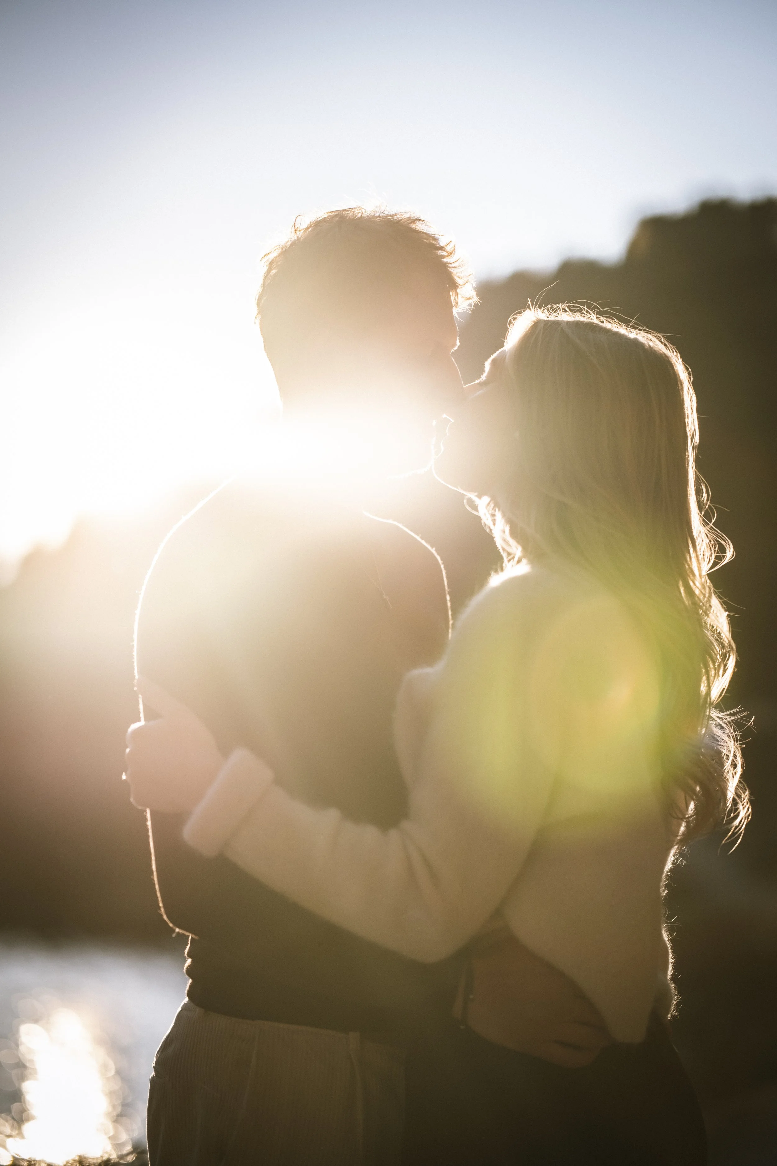 Pärchen küsst sich bei Sonnenuntergang im Freien.