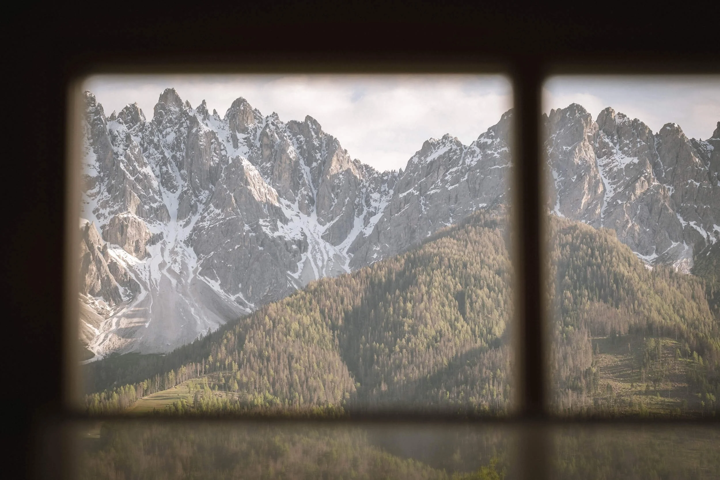 Berglandschaft mit schneebedeckten Gipfeln, durch Fensterrahmen sichtbar