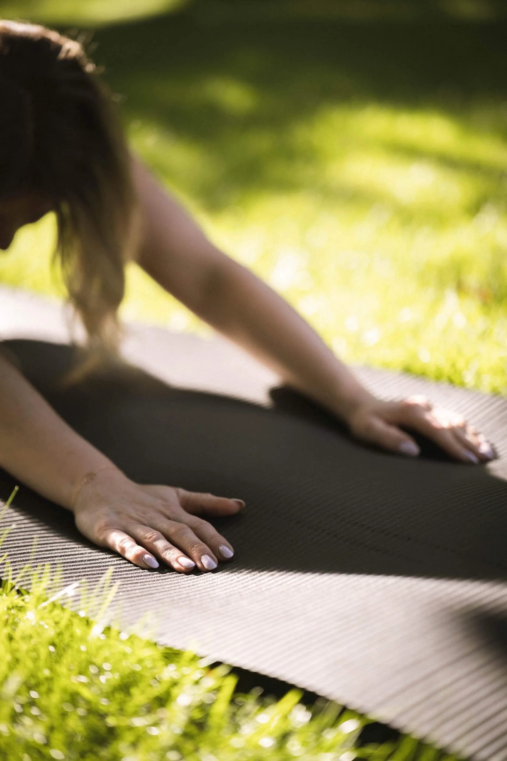 Nahaufnahme einer Person, die im Yoga auf einer Matte im Freien in der Natur trainiert.