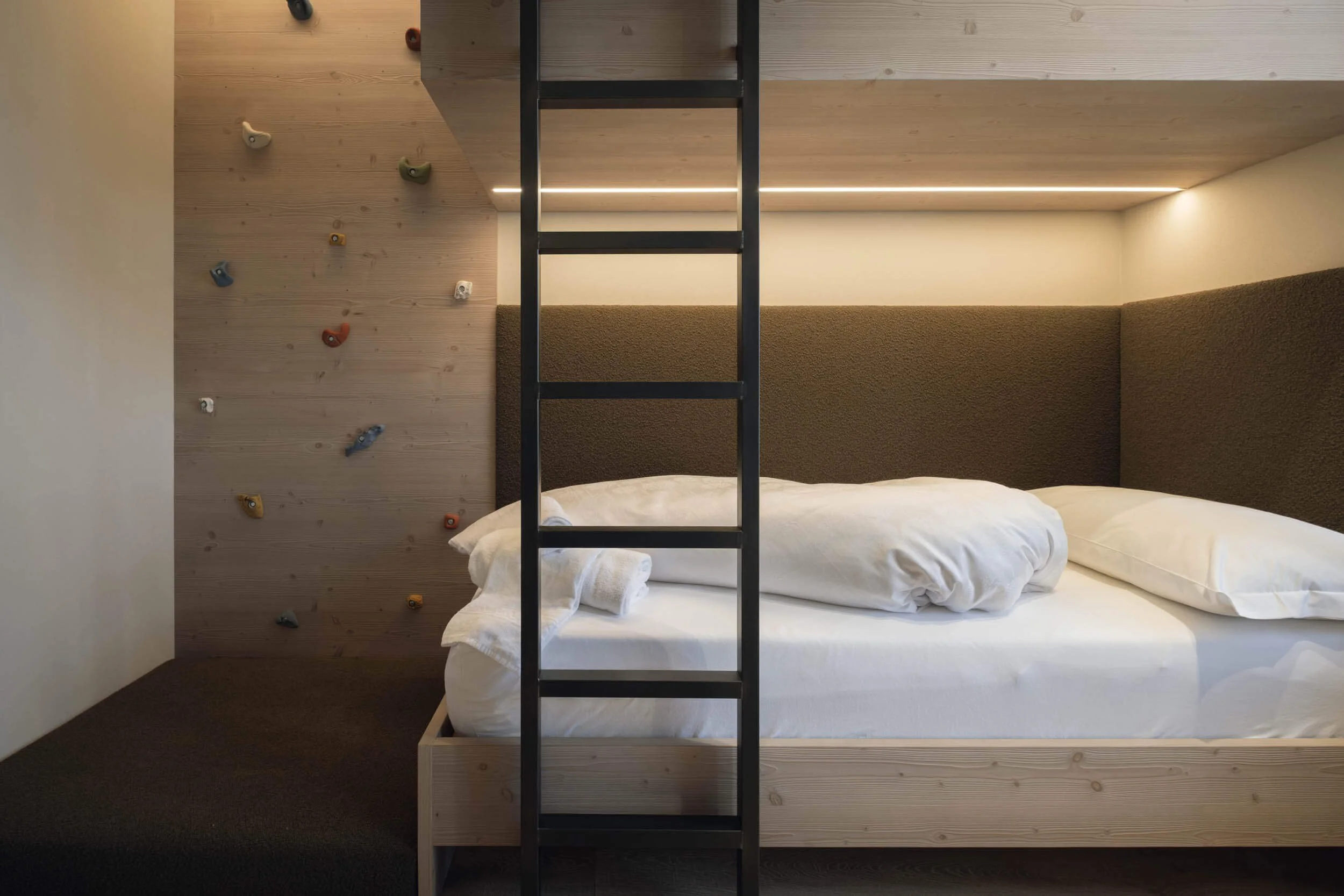 Schlafzimmer mit Matratze, Kletterwand aus Holz und Leiter aus Metall in modernem Stil.