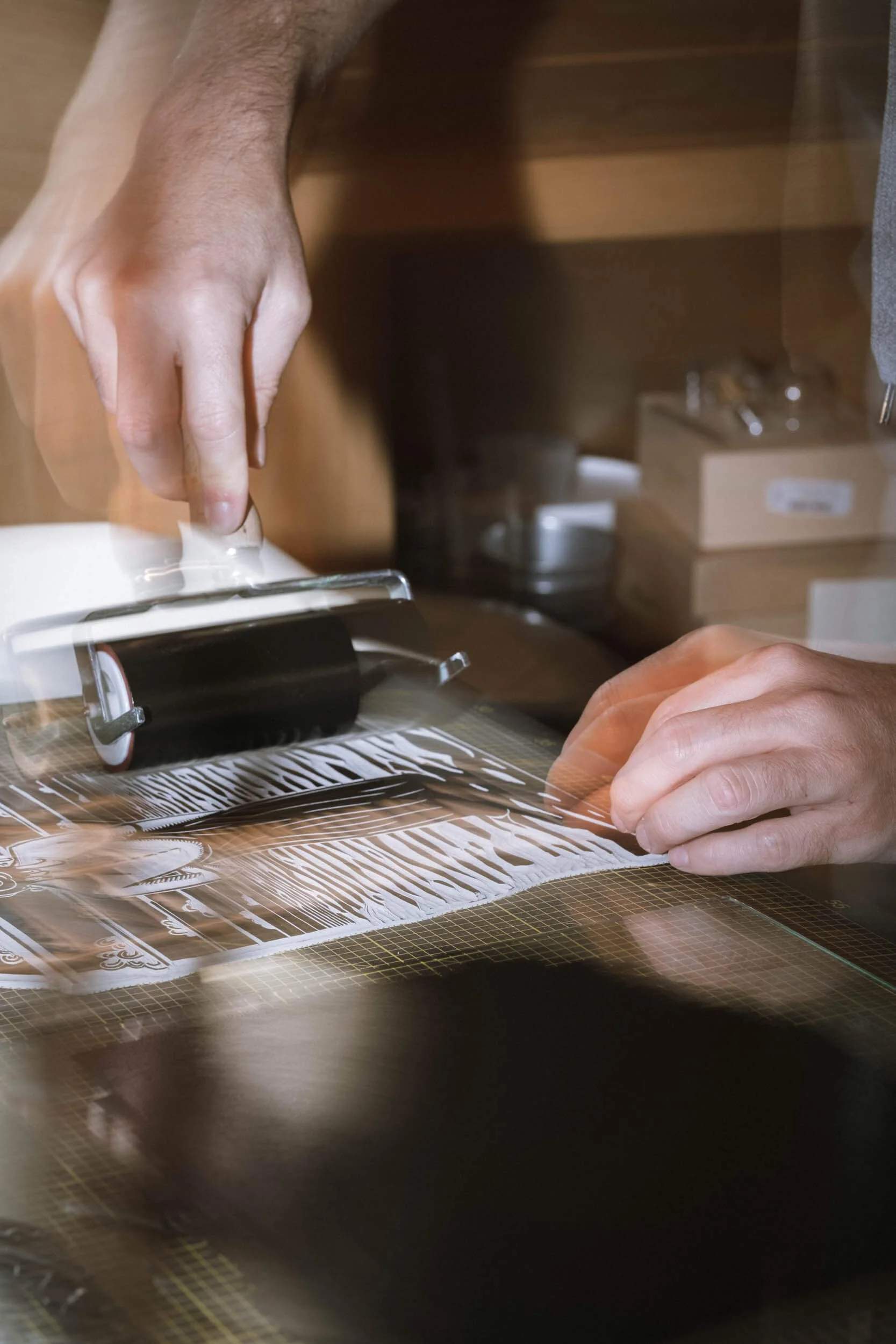 Hand, der mit einem Cutting-Roller auf einem grafischen Schnittmuster arbeitet.