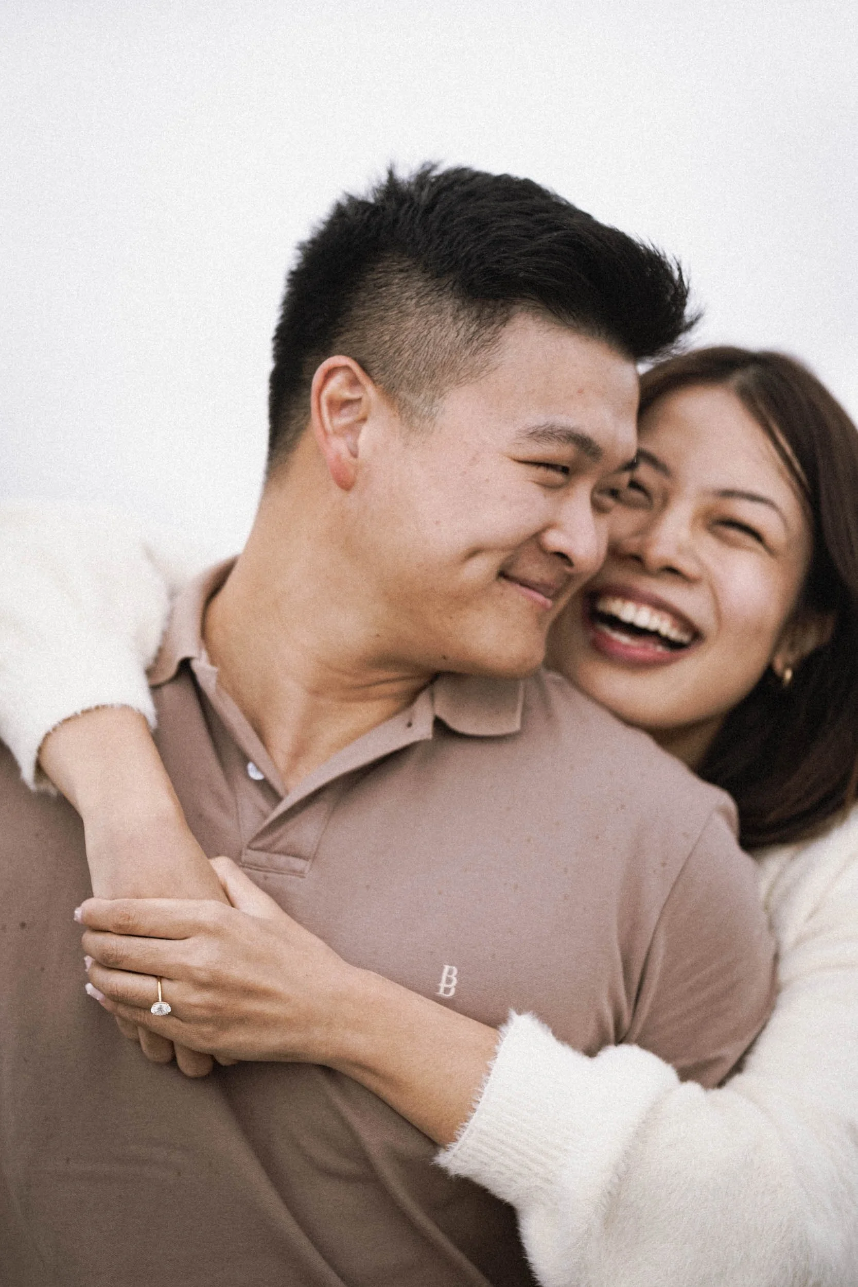 Ein glückliches Paar umarmt sich lachend, Nahaufnahme, auf einem weißen Hintergrund.