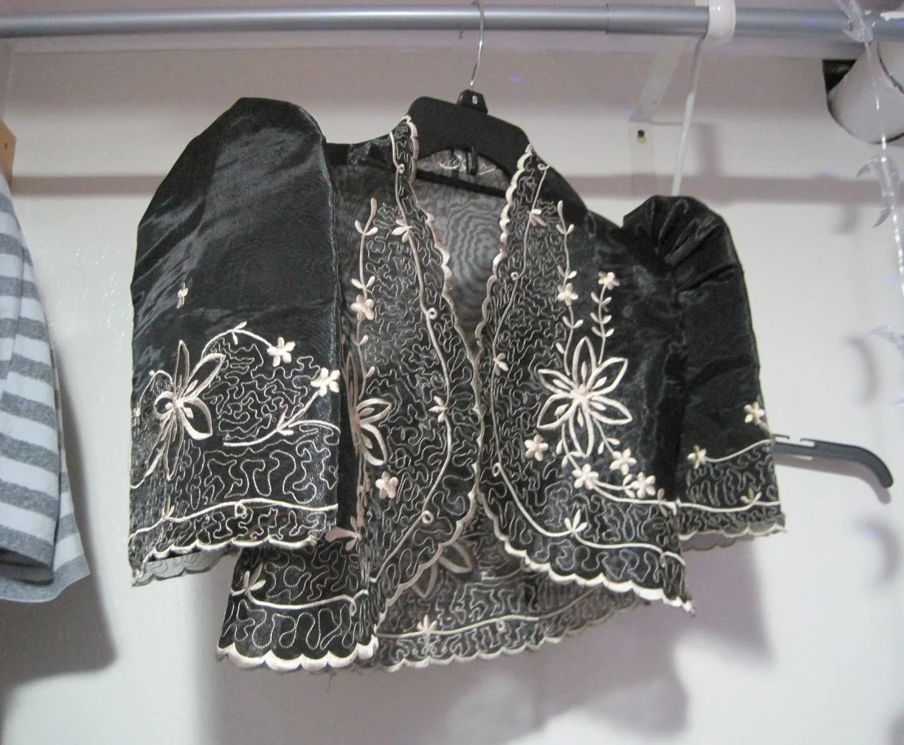 Traditional black velvet bolero jacket with white floral embroidery and puffed sleeves, featuring intricate hand-stitched detailing.