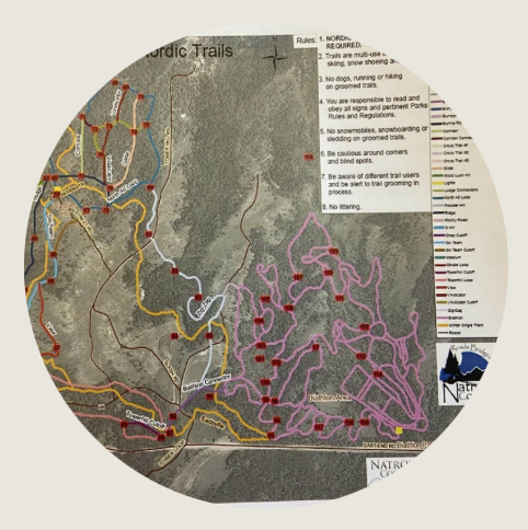 Casper- A close-up of a detailed trail map showing color-coded Nordic skiing and hiking routes winding through mountainous terrain. The map includes labels, boundaries, and notes on trail etiquette.