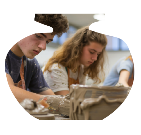 Two students working on a pottery project in a classroom.