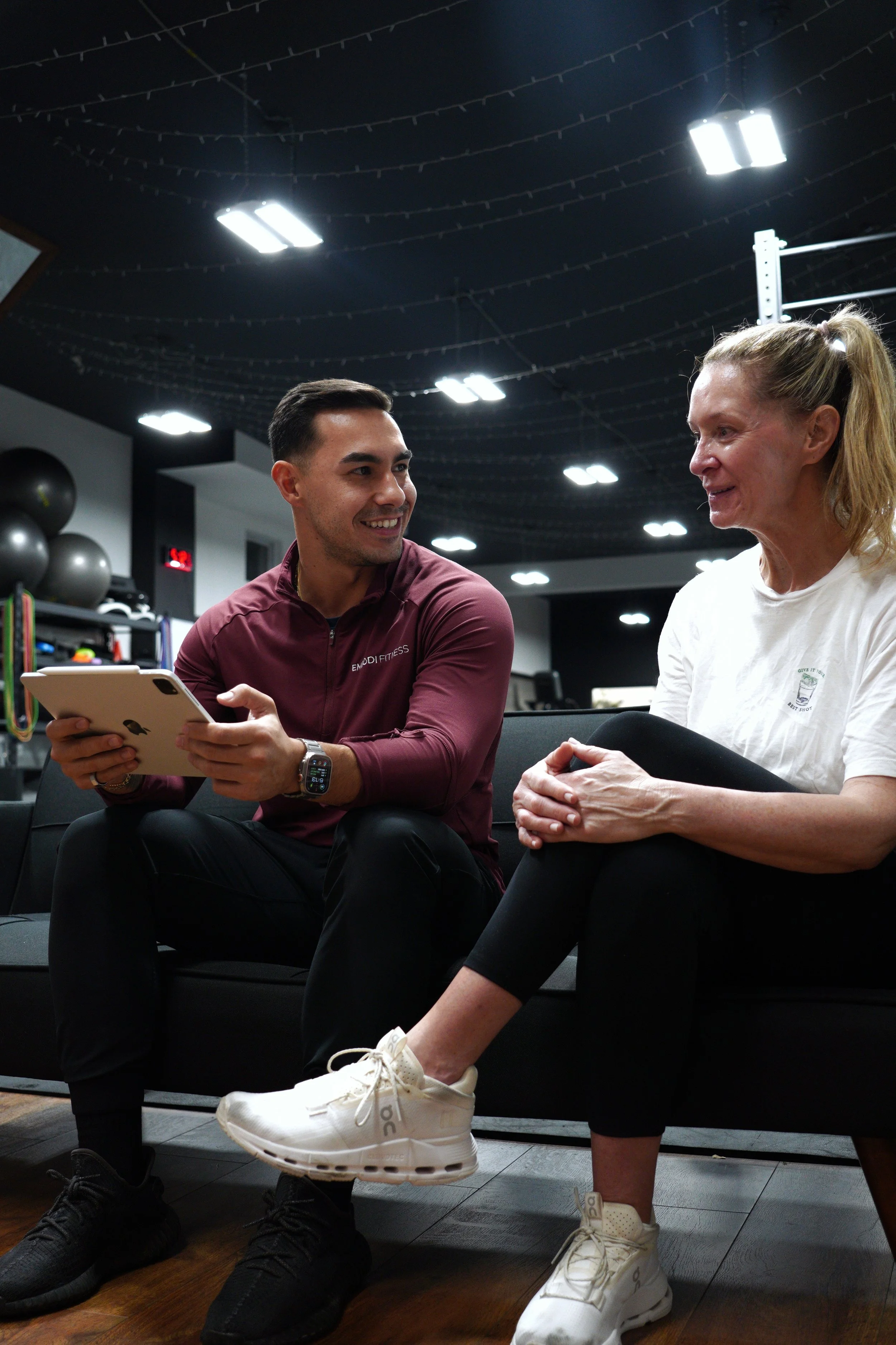 EMBODI Fitness coach meeting with a client during a consultation at our Caldwell, NJ training studio, reviewing progress and goals before beginning structured training.