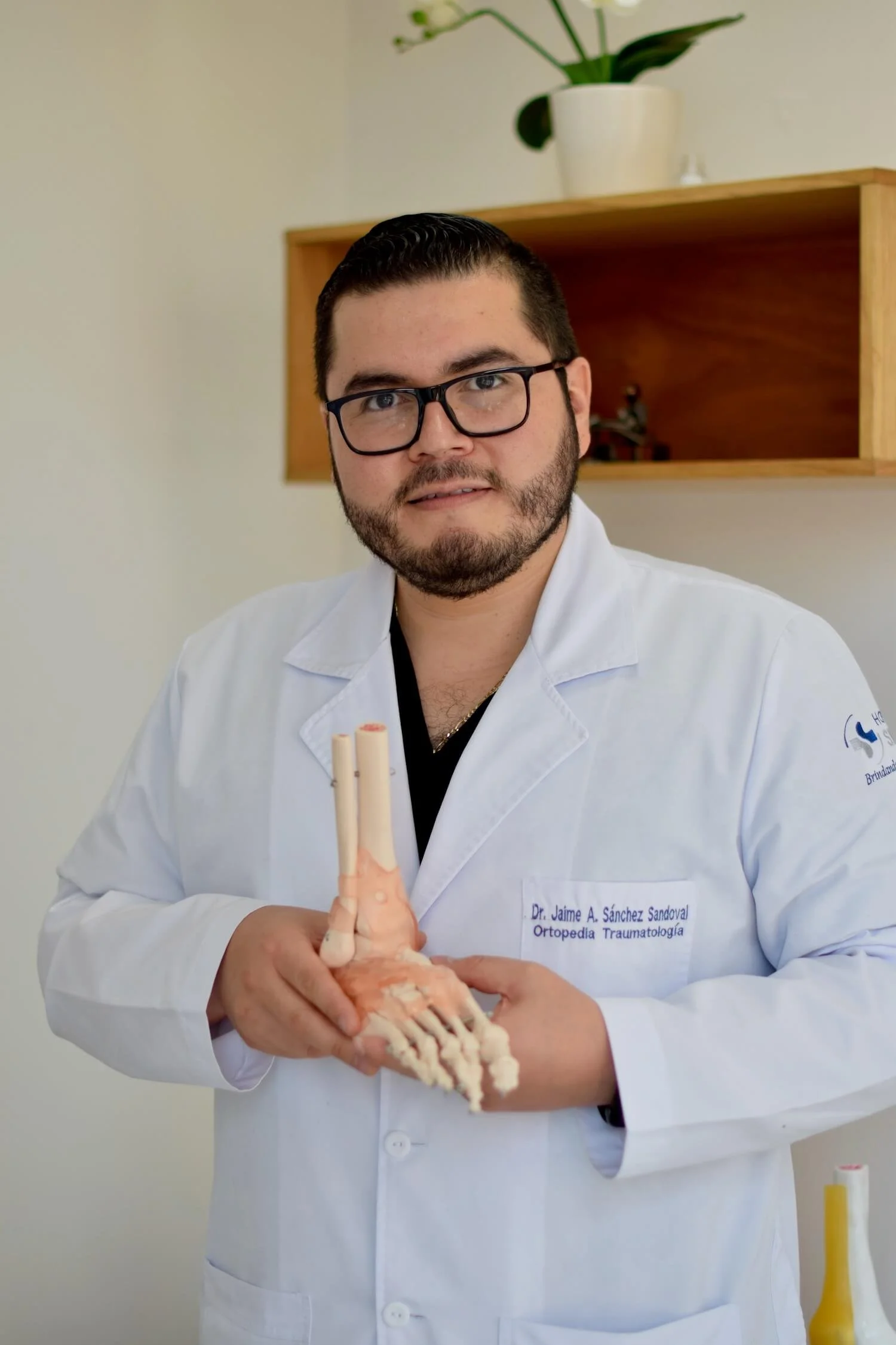 Ortopedista CDMX sosteniendo modelo óseo