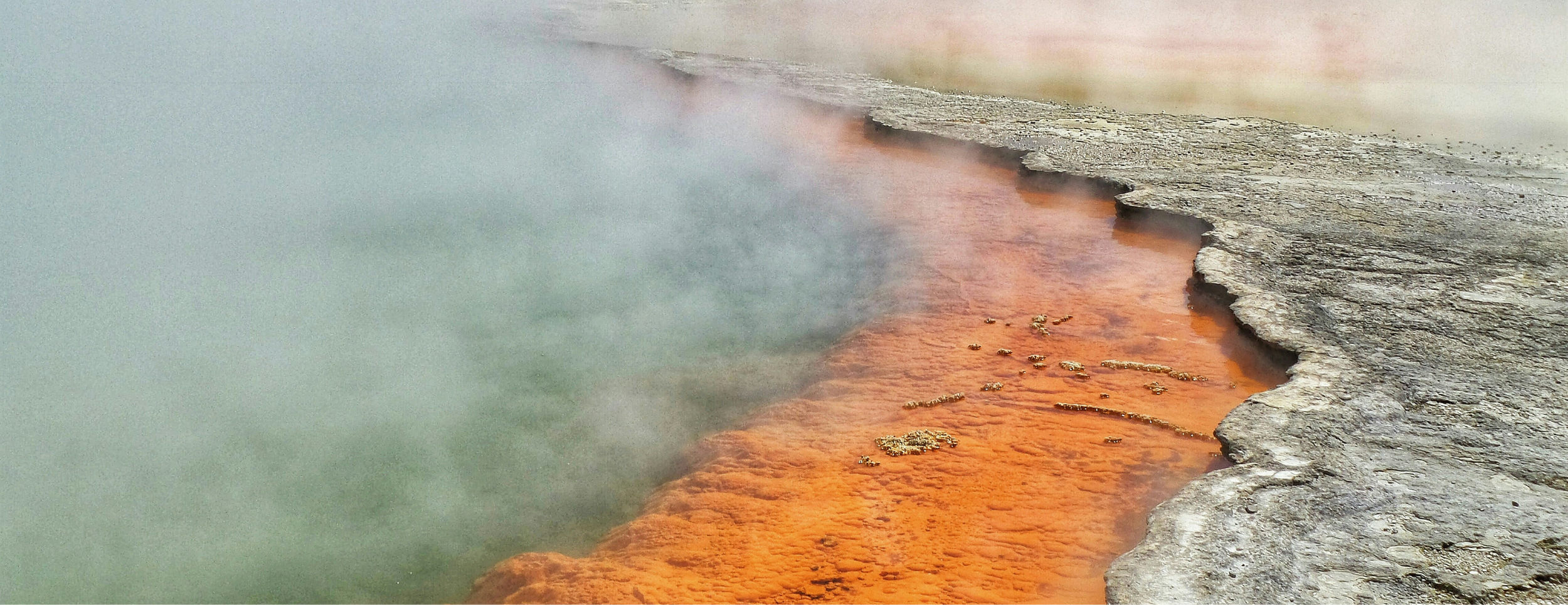 Steaming geothermal hot spring with vivid mineral deposits illustrating natural geothermal energy potential for tribal utility-scale power development
