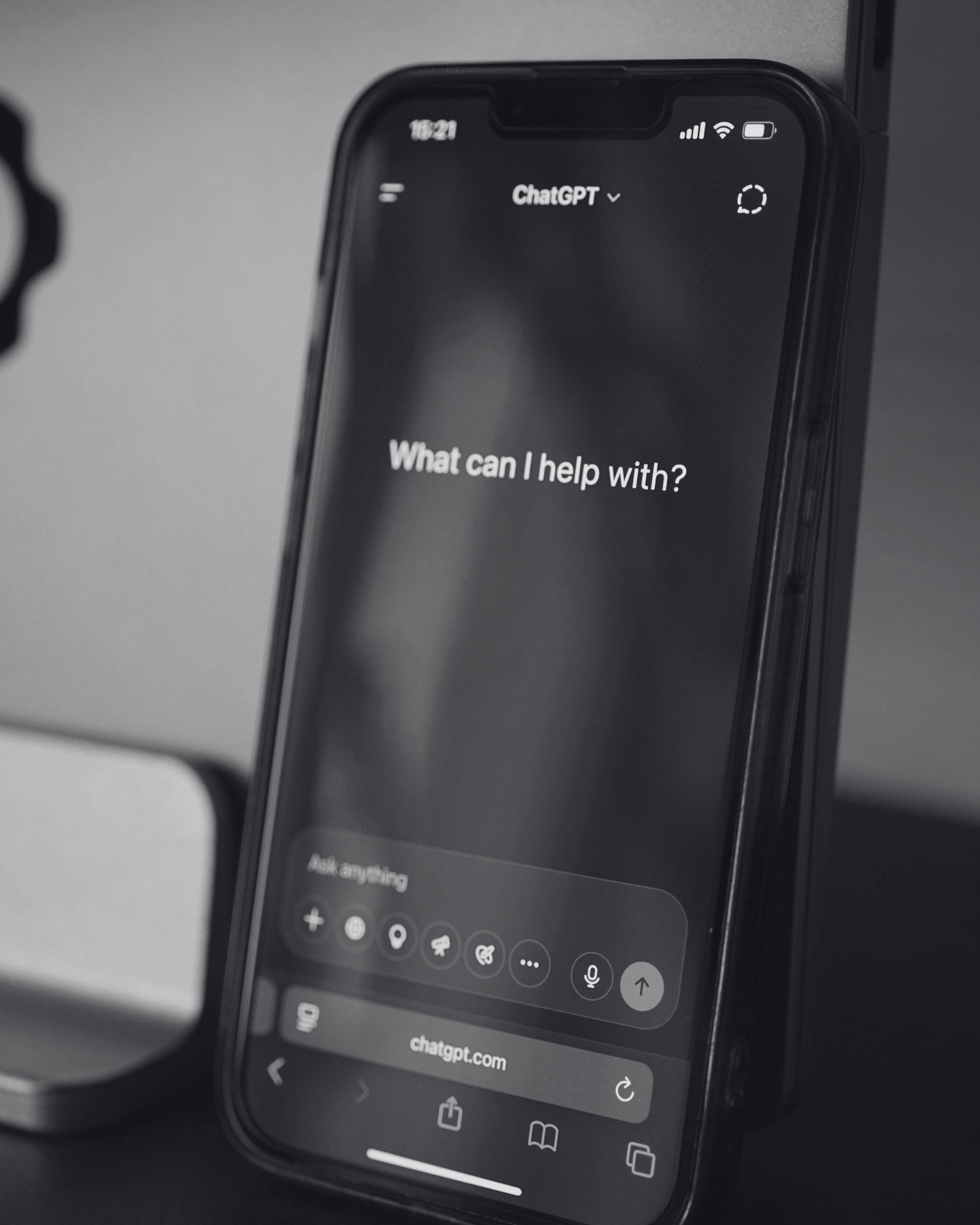 Smartphone screen showing ChatGPT with the text What can I help with, representing logo design, branding, and AI-powered marketing optimization by Seven4 Marketing.