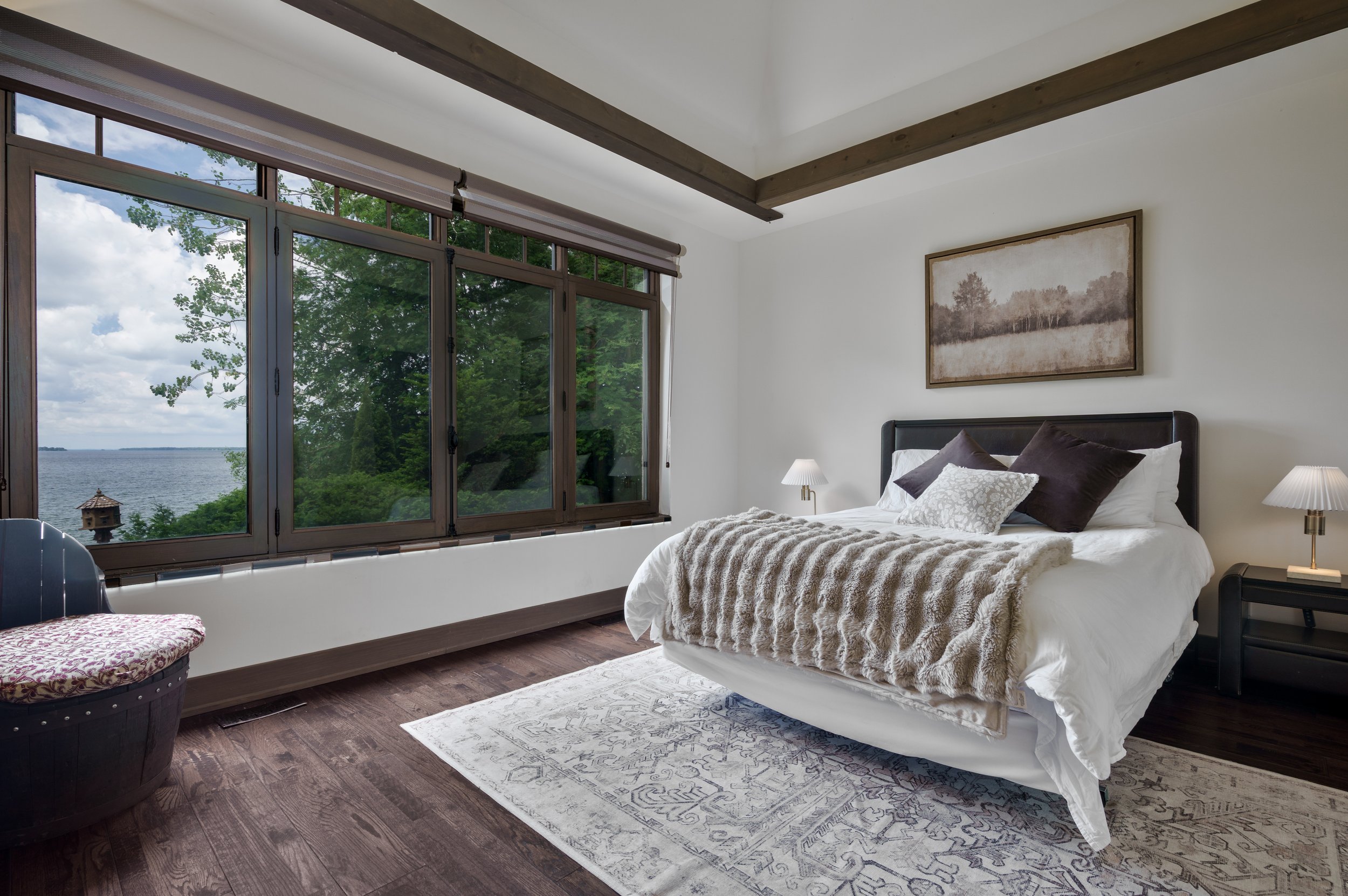 Primary bedroom featuring large windows with a lake front view in Brock - Premium  Real Estate Photography