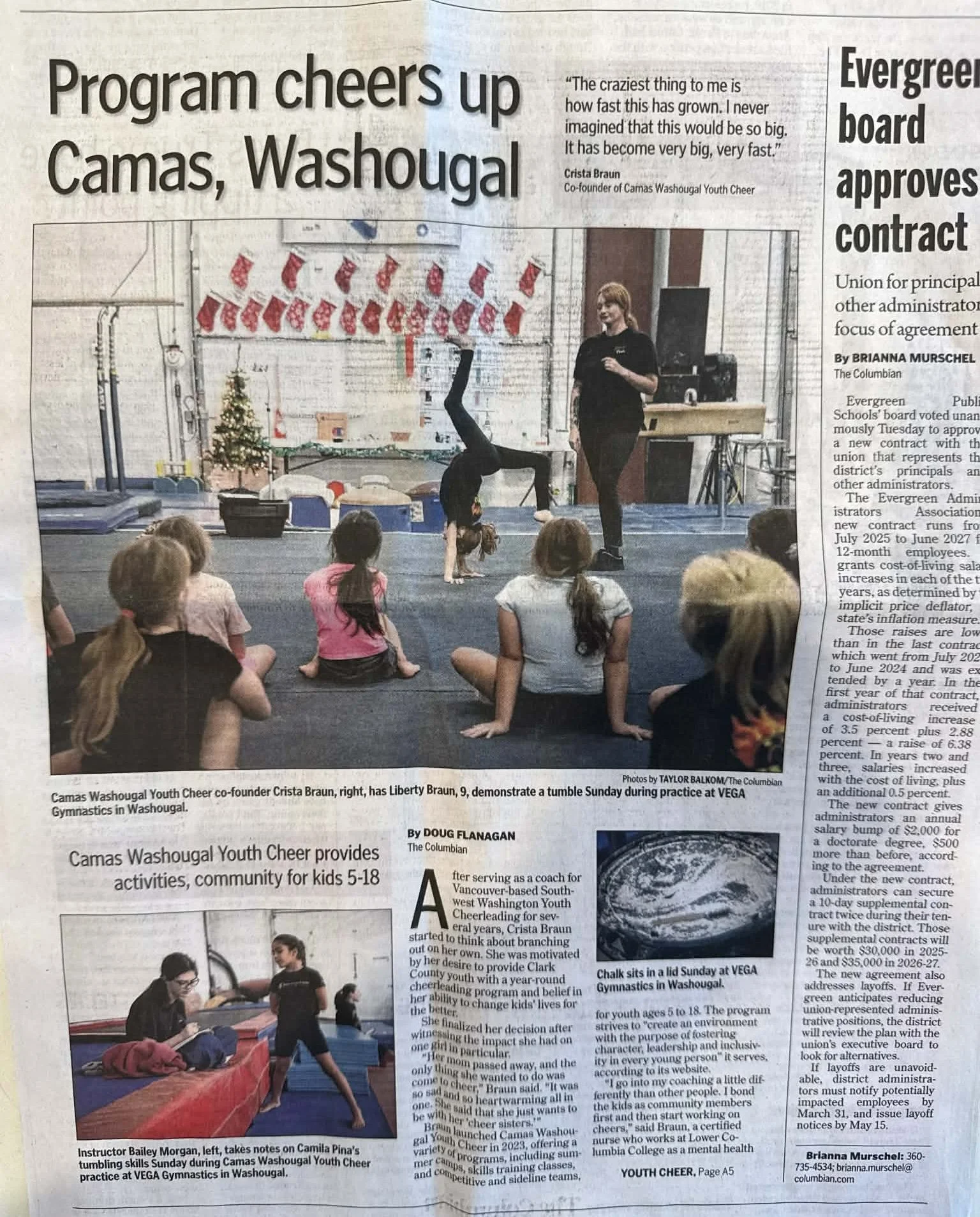 Children watching a gymnastics demonstration with an instructor in a gym decorated for Christmas, including stockings and a Christmas tree, as part of a youth cheer program.