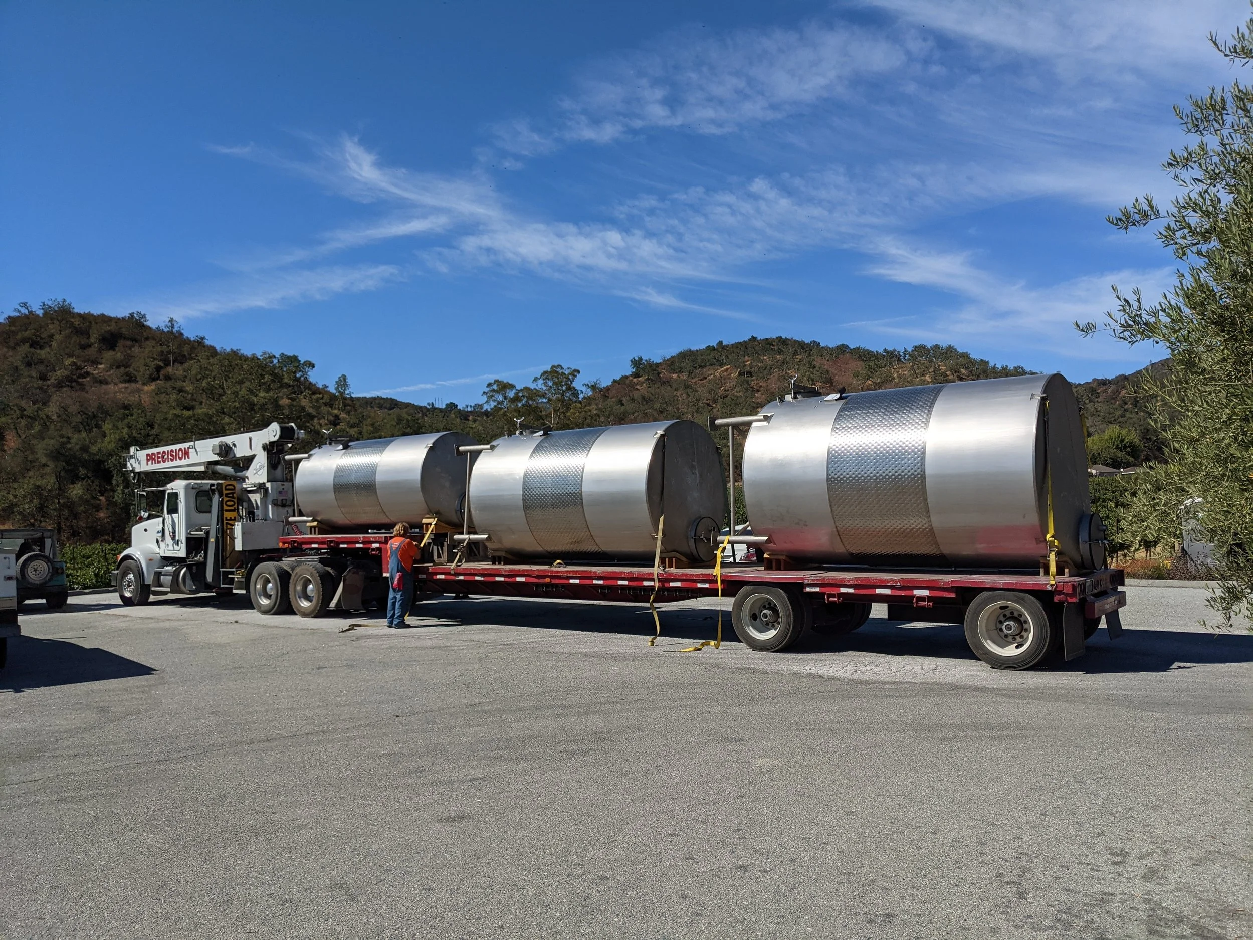 Stainless steel winery tanks being delivered for production facility installation.