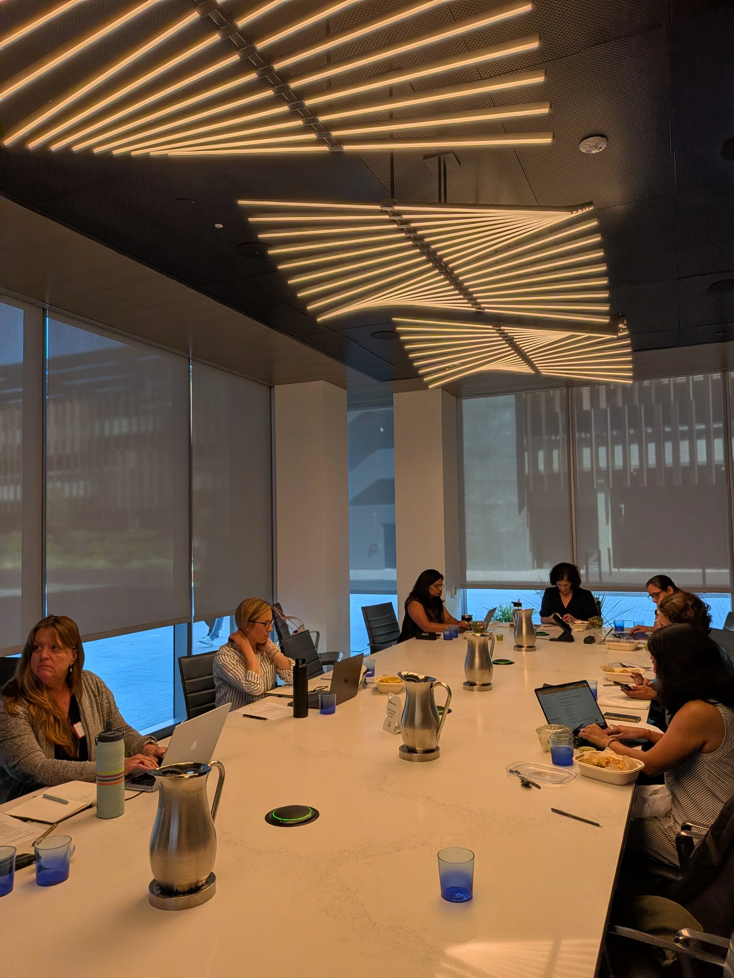 Workshop participants seated around a table, actively collaborating and using AI-accelerated tools to audit their Q1 performance and plan their 90-day sprints.