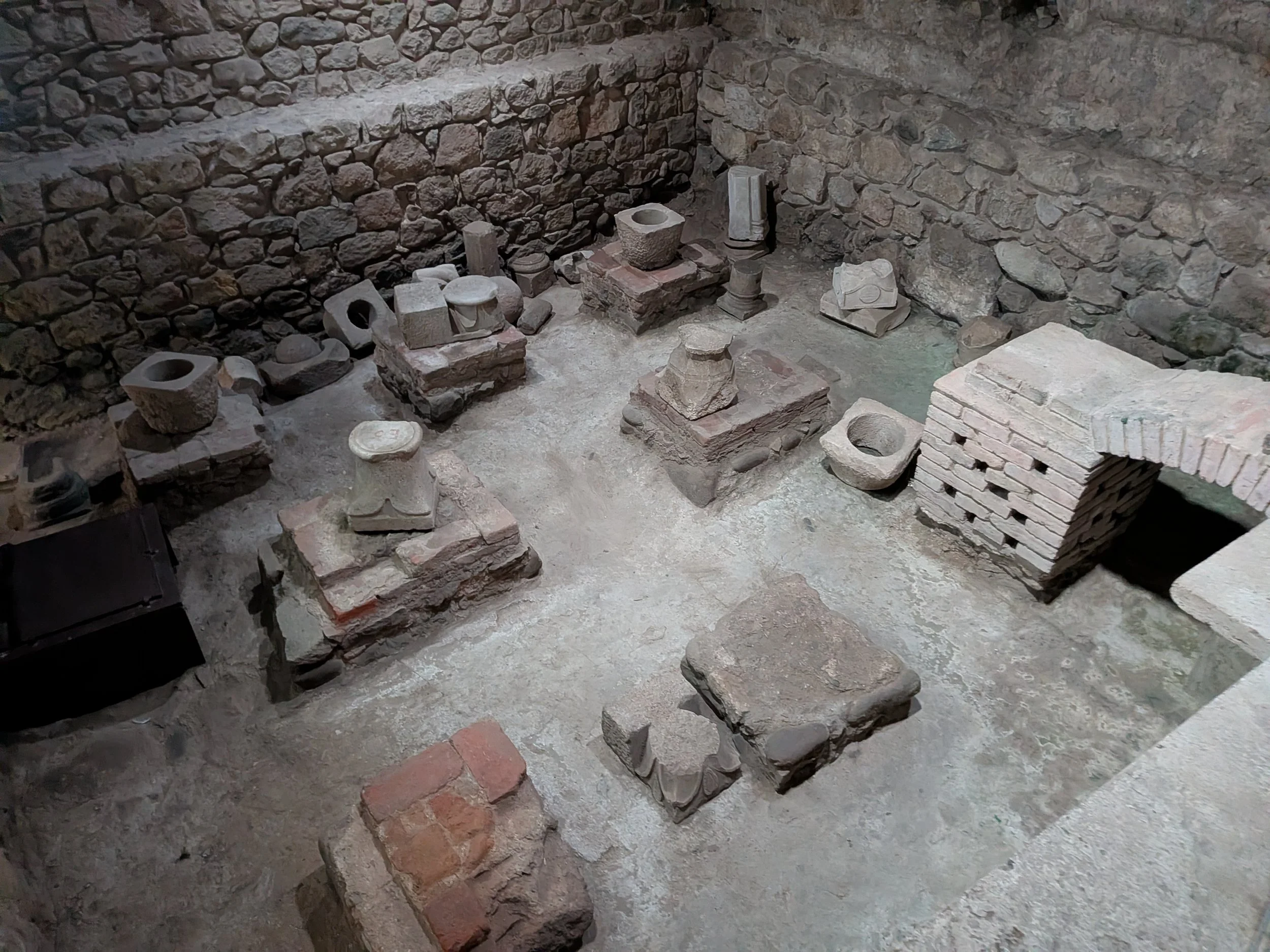 An ancient stone archaeological excavation site with exposed brick foundations and stone pillars, representing Karl Weick's theory of organizing, sensemaking, and structural frameworks.