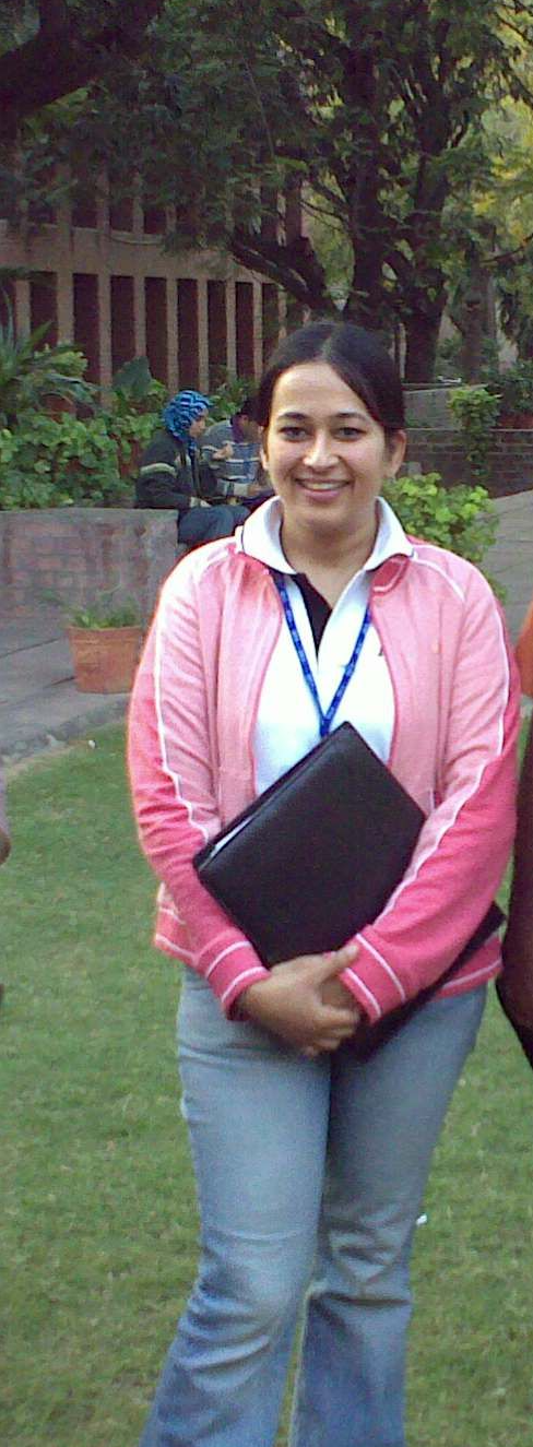 Portrait of Twisha Anand during her academic PhD journey, holding a notebook on a campus lawn, illustrating personal scaffolding, intrinsic discipline, and foundational organizational research.