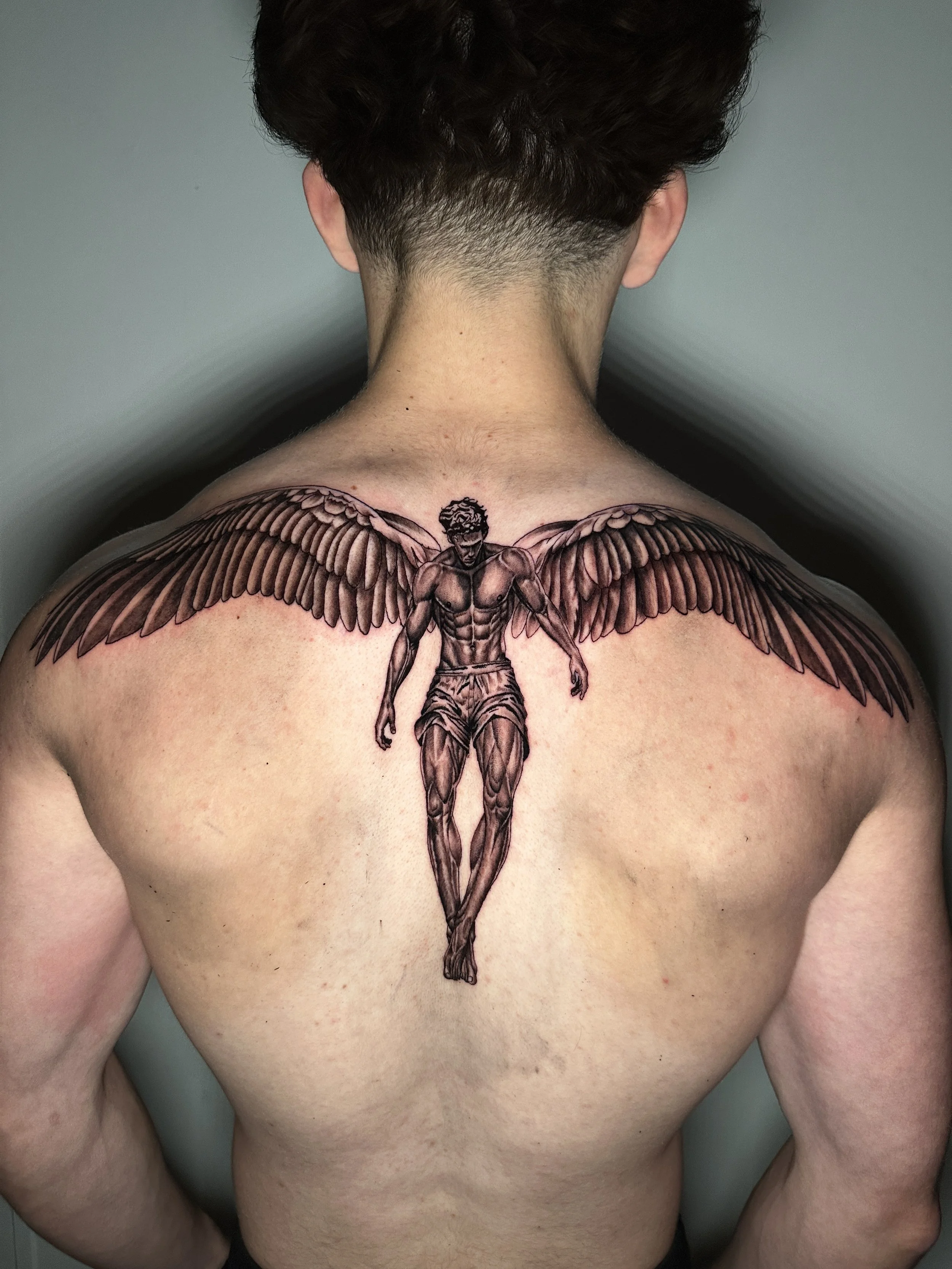 Angel tattoo on upper back by Oscar