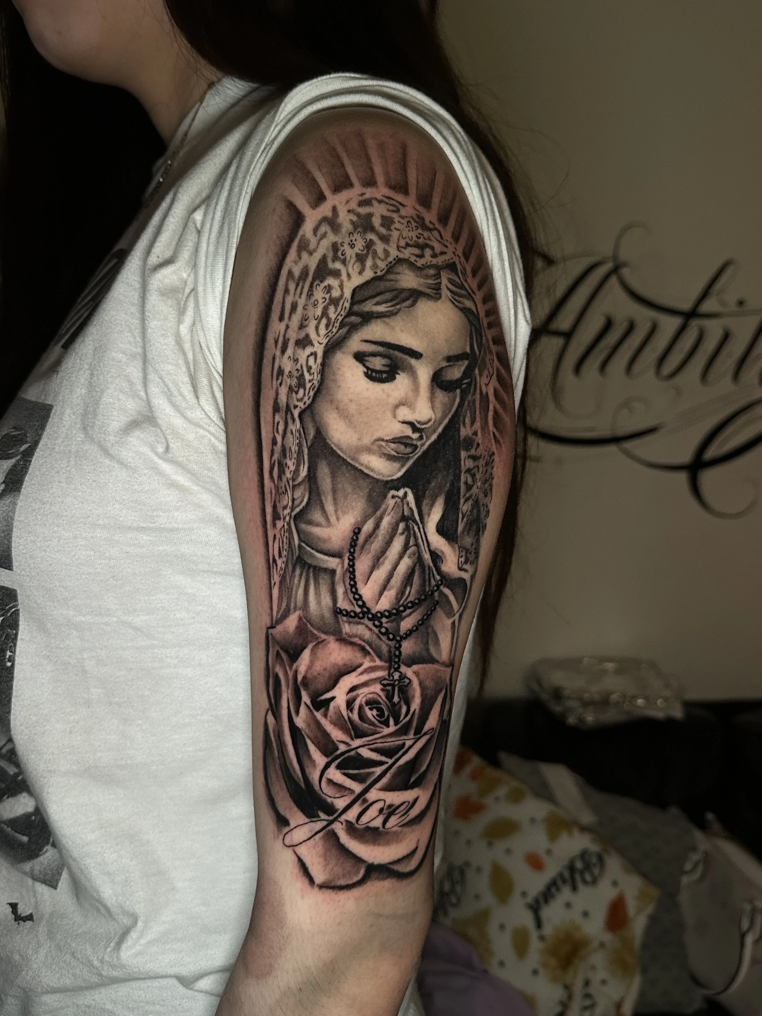 Praying Virgin Mary with rose tattoo done in black and grey realism by Oscar 