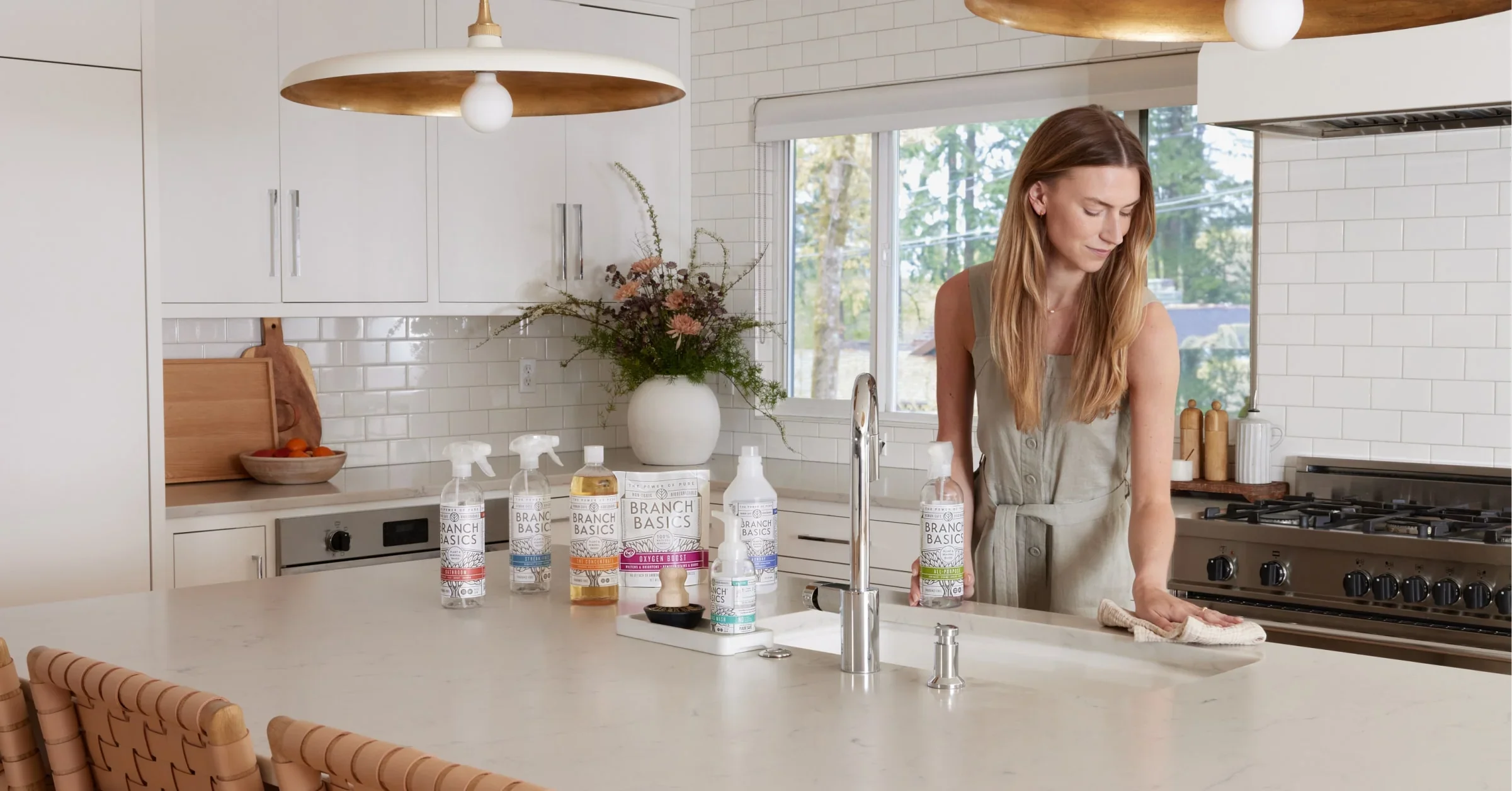 A woman refiling Branch Basics Clear bottle