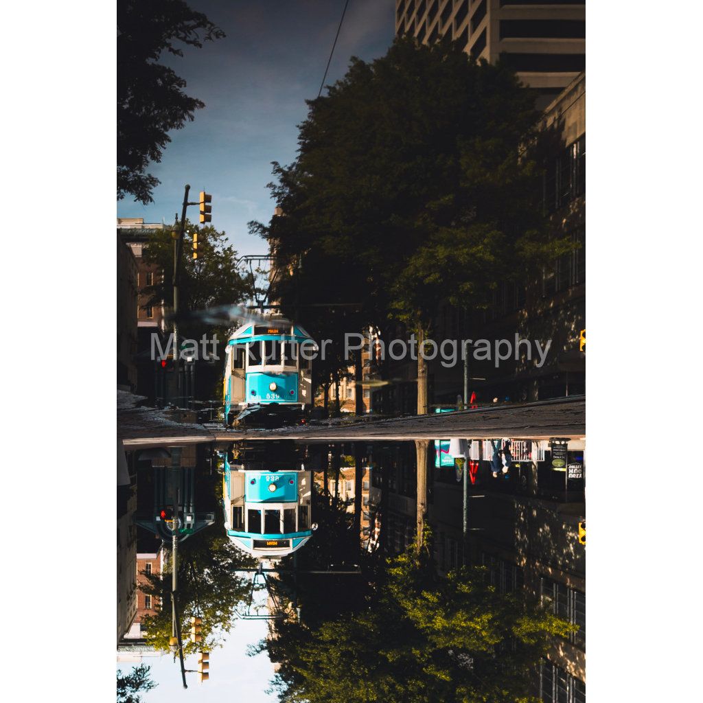 Reflection of a blue trolley on Main Street in Memphis TN