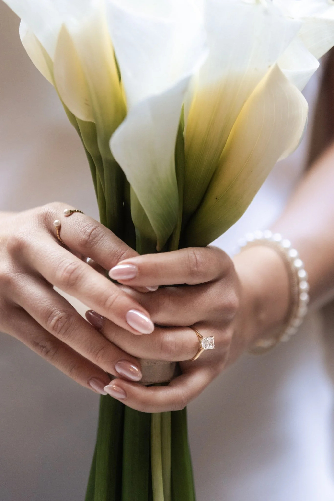 Close-up of bride's hands and wedding ring holding a bouquet of flowers