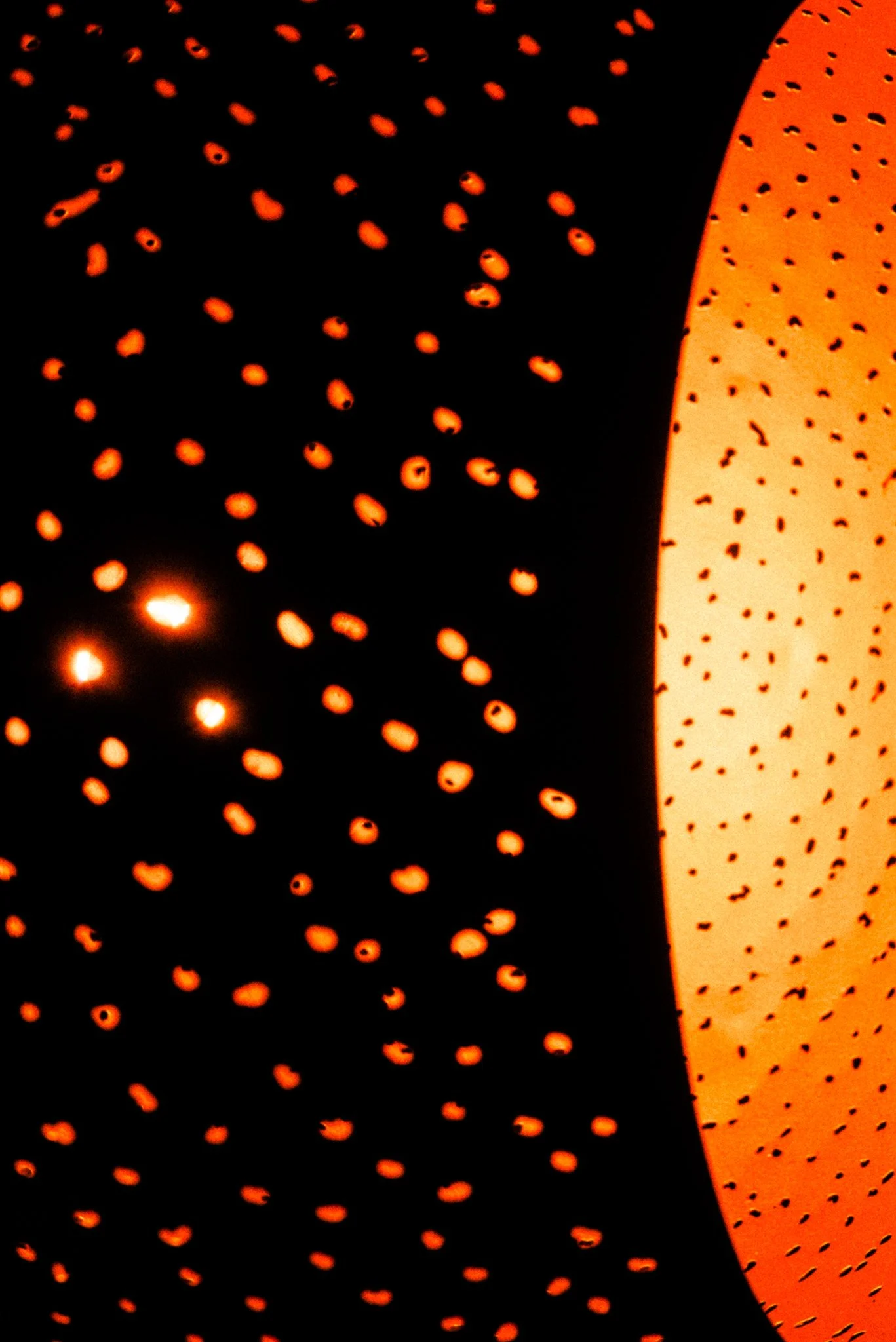 Close-up of illuminated decorative orange and black patterned surfaces.