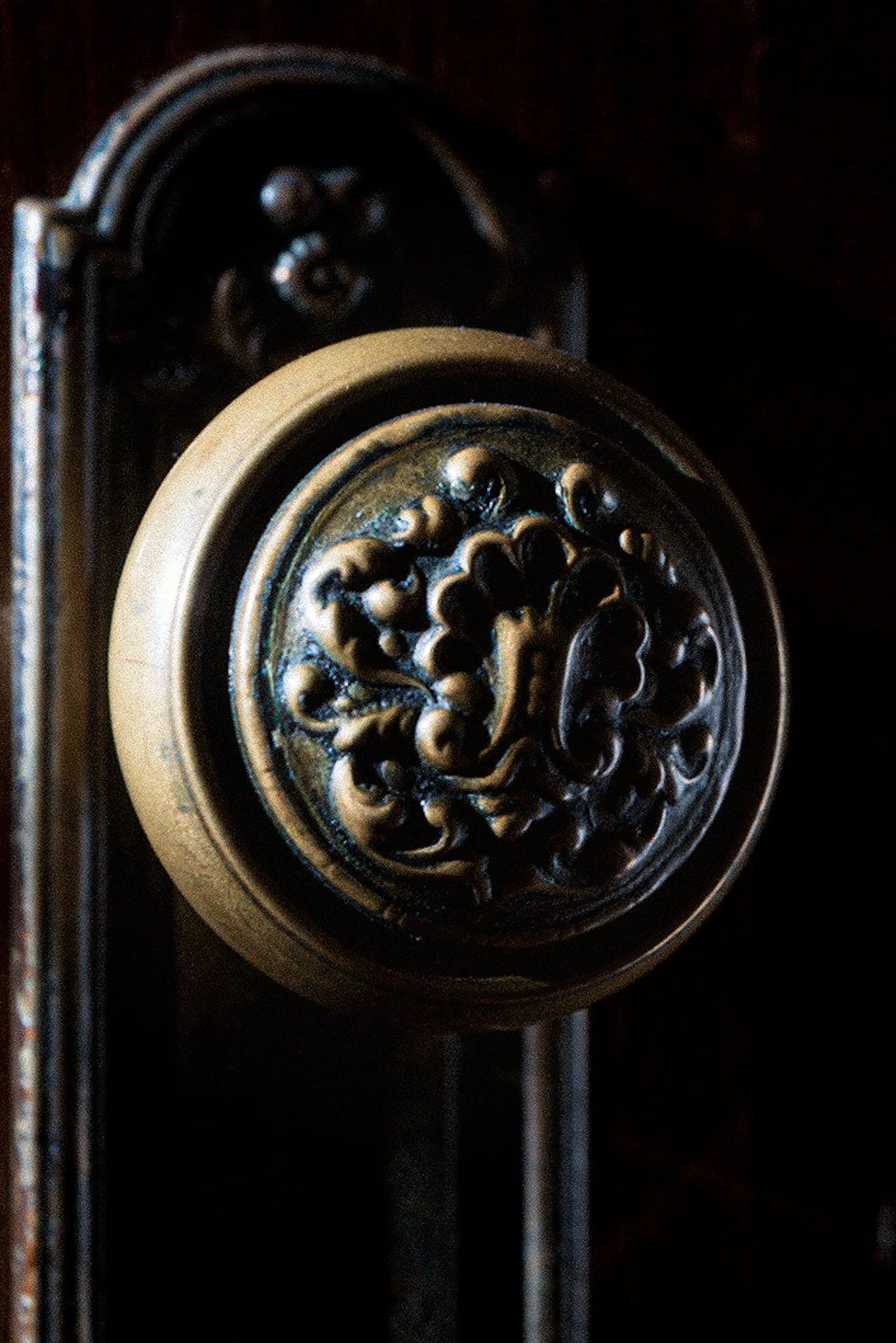 Close-up of the decorative top of a vintage grandfather clock with intricate carvings in dark wood.