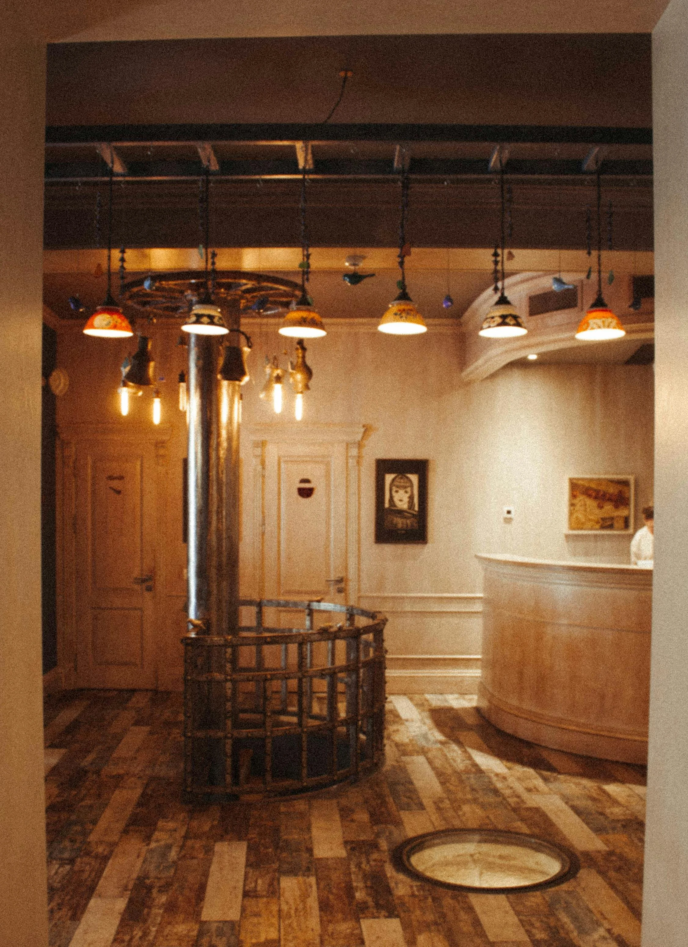 Warm spa entrance with pendant lighting, wood floors, and a reception desk — an example of environment design that influences psychological state upon arrival.