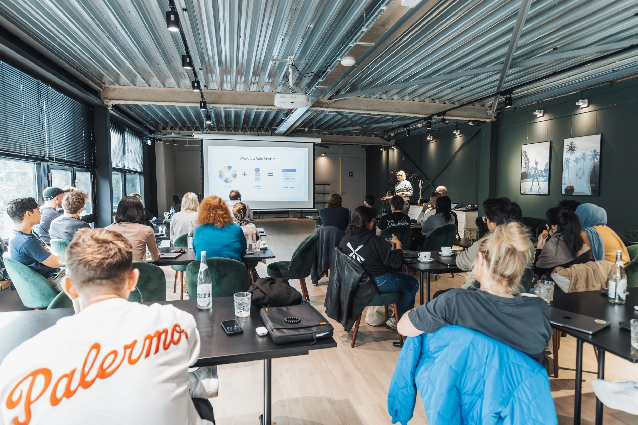 Diverse group attending a community workshop with a presenter and projection screen
