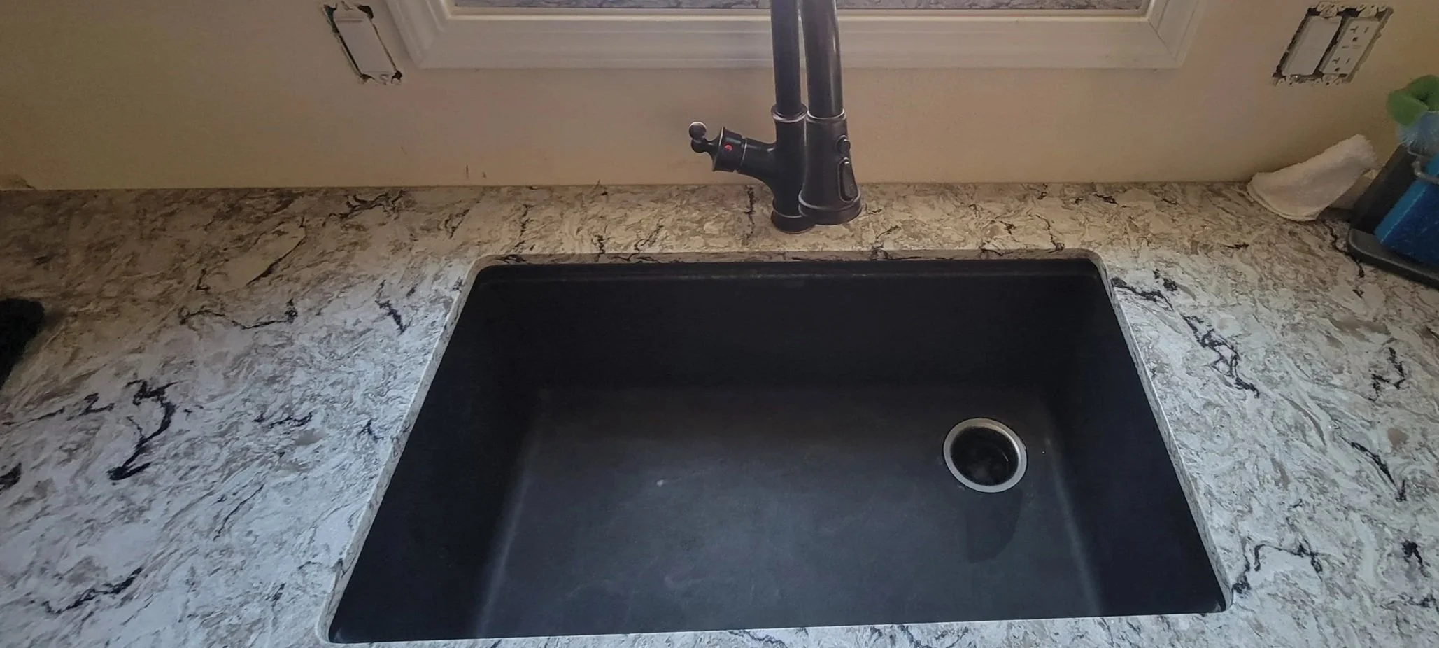 Newly installed kitchen composite sink with beautiful stone countertop.