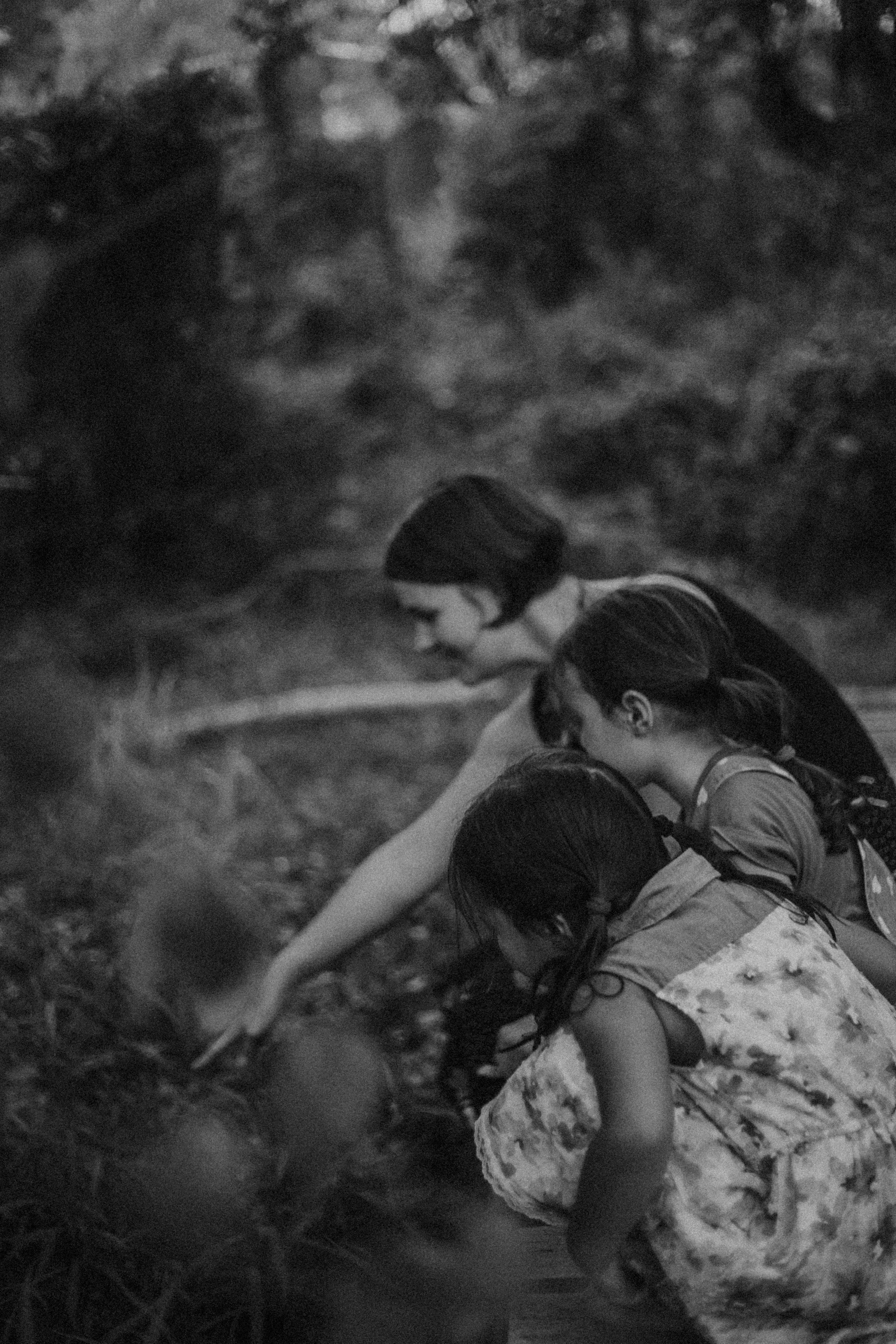 Three girls picking apples from a tree.