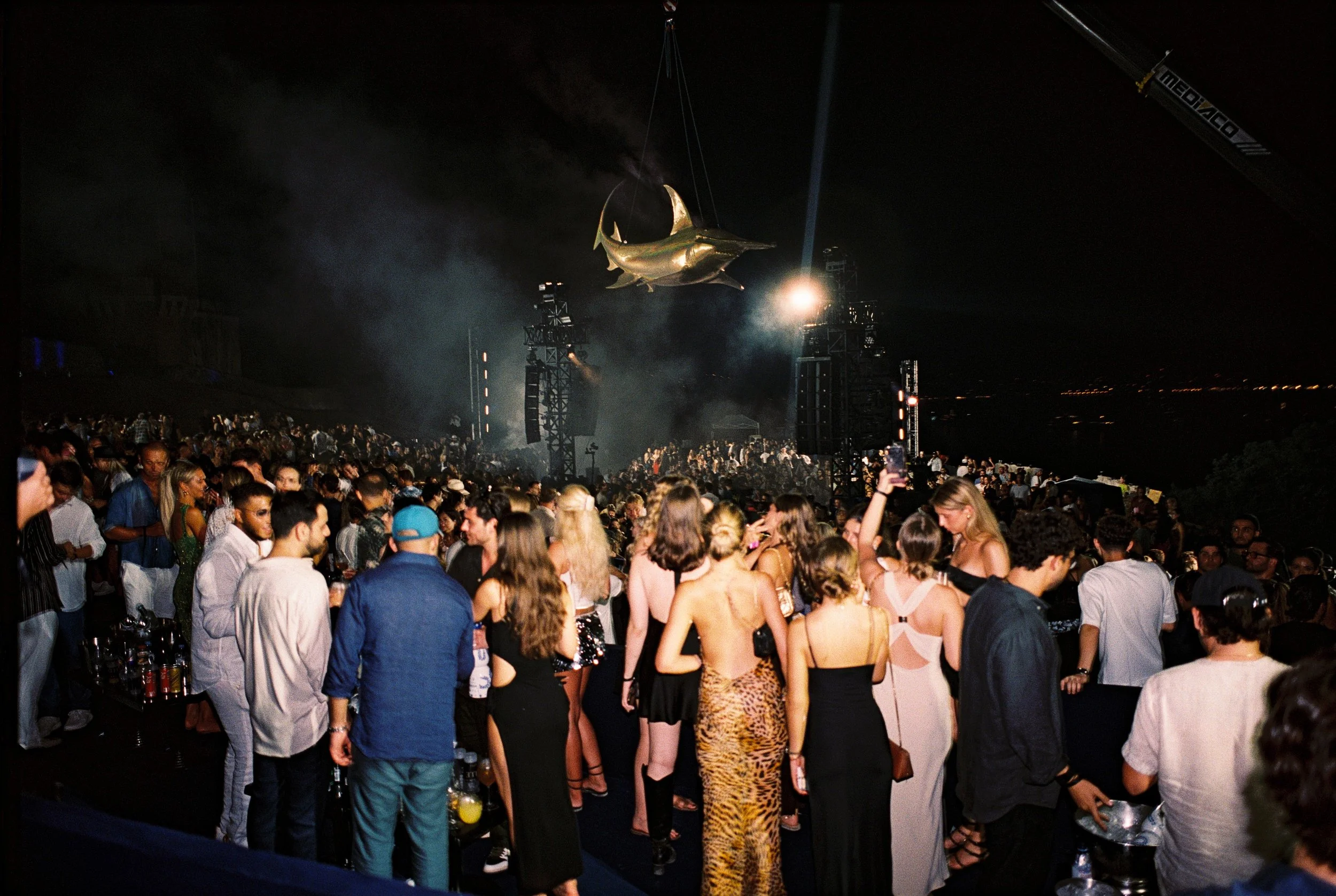 Wide shot of the stage and audience setup at Isabelle Music Festival in Saint Tropez bright, airy venue and the giant gold shark disco ball.