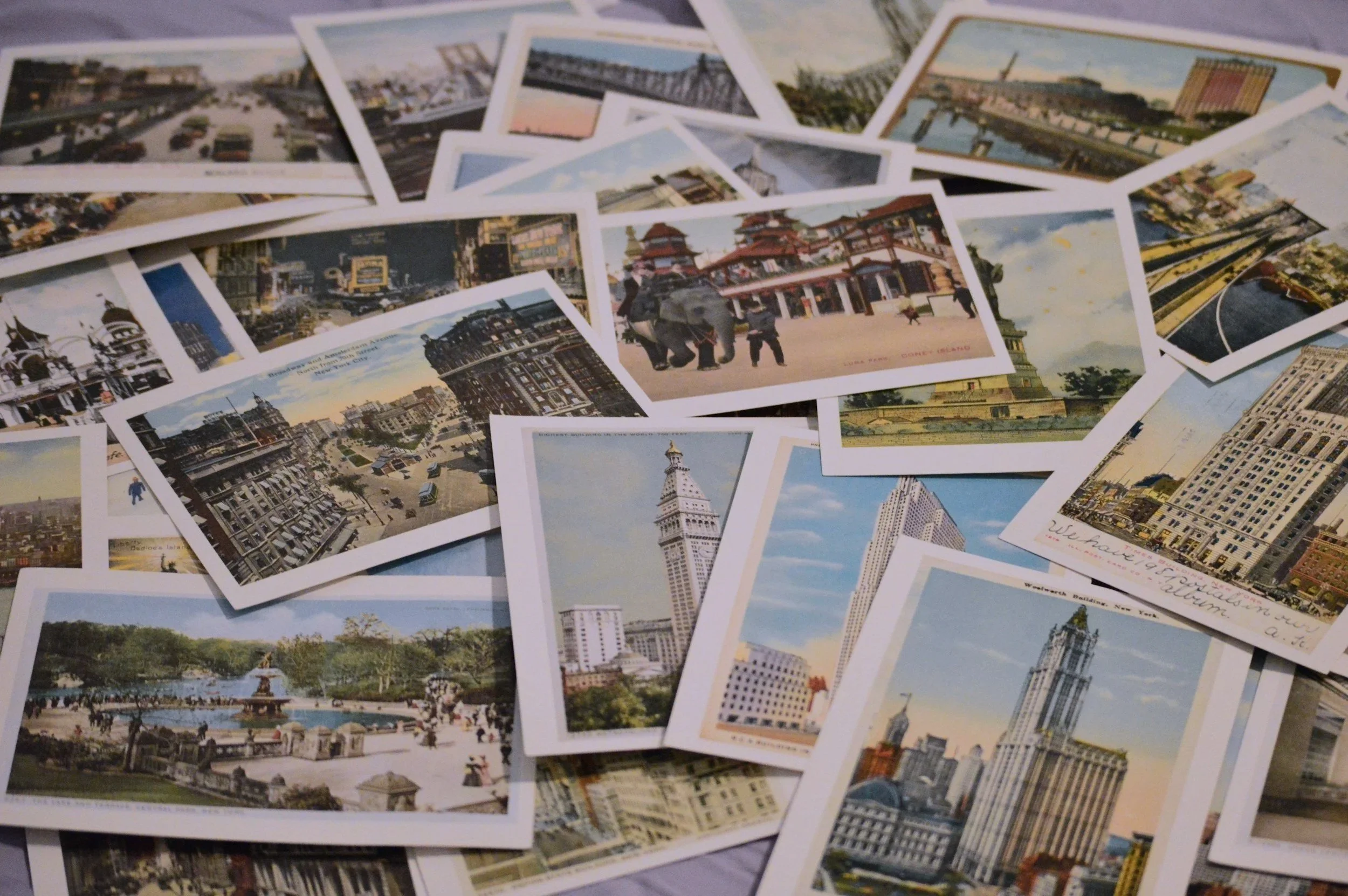 A collection of colorful cityscape postcards featuring landmarks, buildings, parks, and streets from various locations.