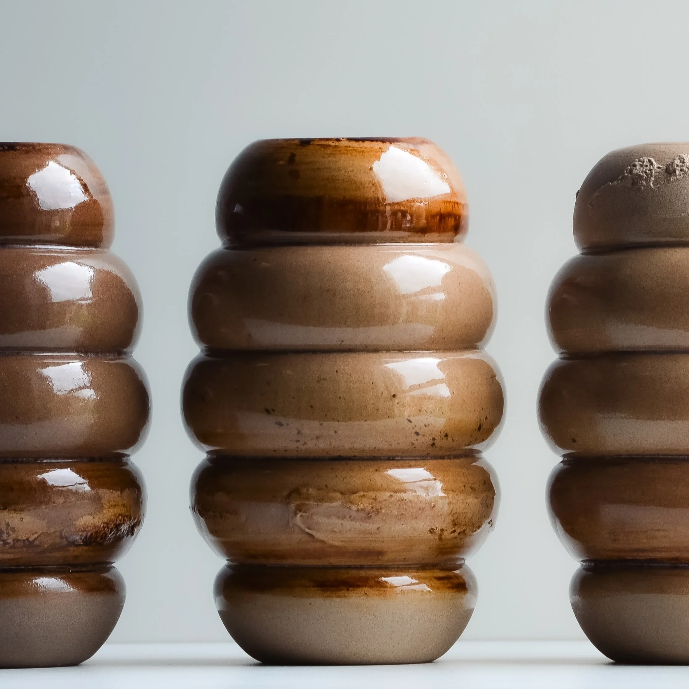ceramic tan bud vase on white background