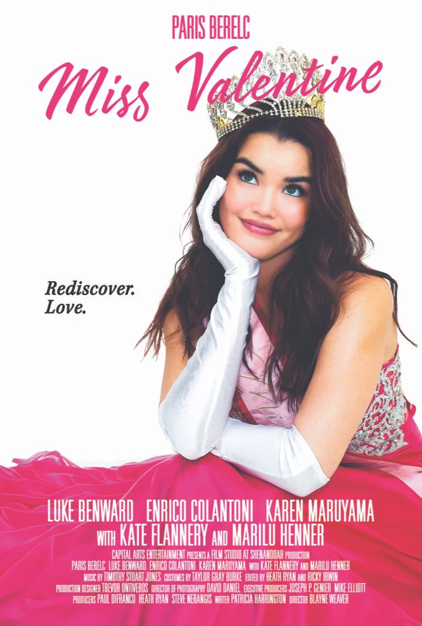 A promotional poster featuring a woman wearing a tiara and a pink dress. She has long wavy brown hair and is smiling softly, resting her chin on her hand covered with a white glove. The poster is for a film titled "Miss Valentine," with the tagline "Rediscover. Love." The woman is likely a beauty queen or pageant participant.