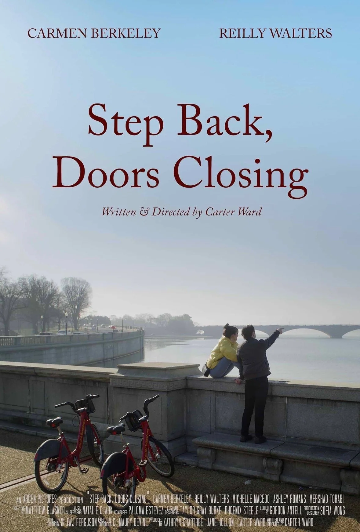 Book cover titled 'Step Back, Doors Closing' by Carmen Berkeley and Reilly Walters with a photo of two women near a river, one pointing, bicycle in front, bridge in the background.