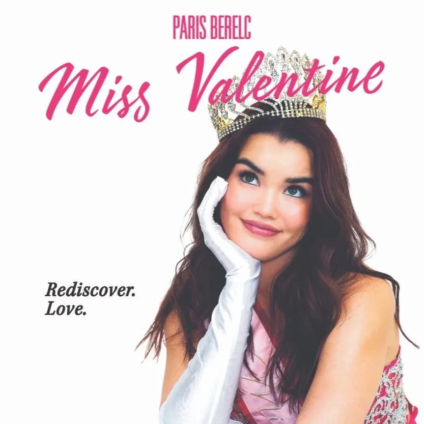 Miss Valentine from Paris Berelc wearing a crown and pink dress, resting her chin on her hand with a white glove, smiling against a white background, with pink and black text reading "Paris Berelc Miss Valentine" and "Rediscover. Love."