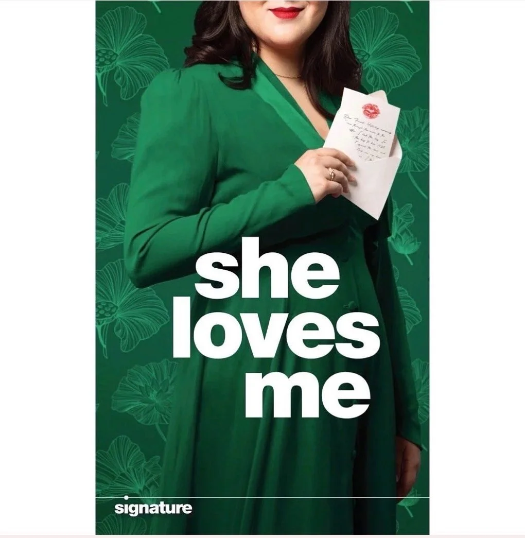 Cover of a magazine titled 'she loves me' featuring a woman in a green dress holding a handwritten note with a lipstick kiss stamp. Background is green with floral patterns.