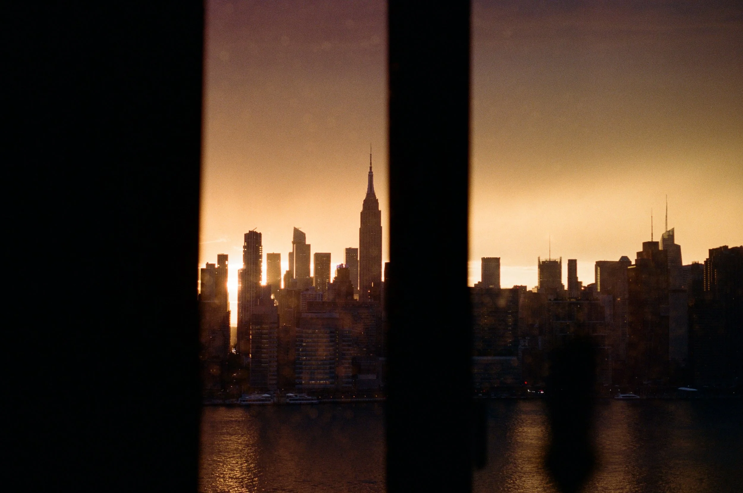 City skyline with buildings and the Empire State Building seen through a window