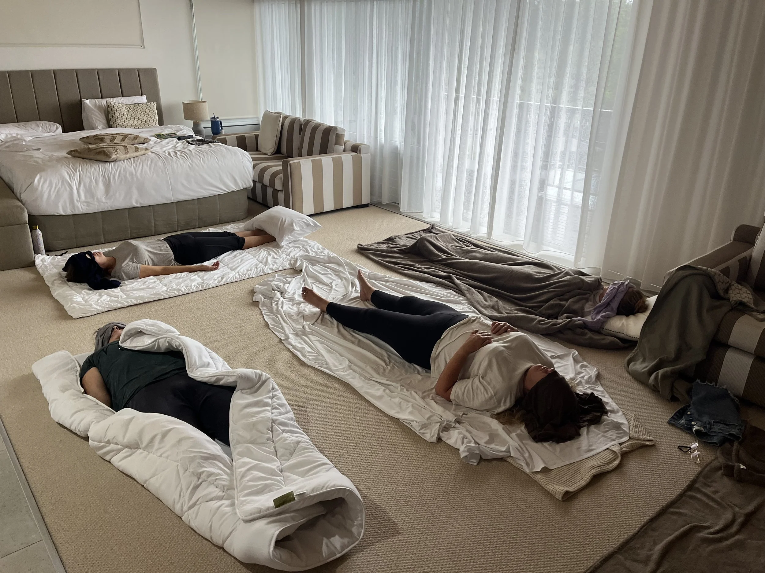People laying in shavasana during breathwork at yoga studio
