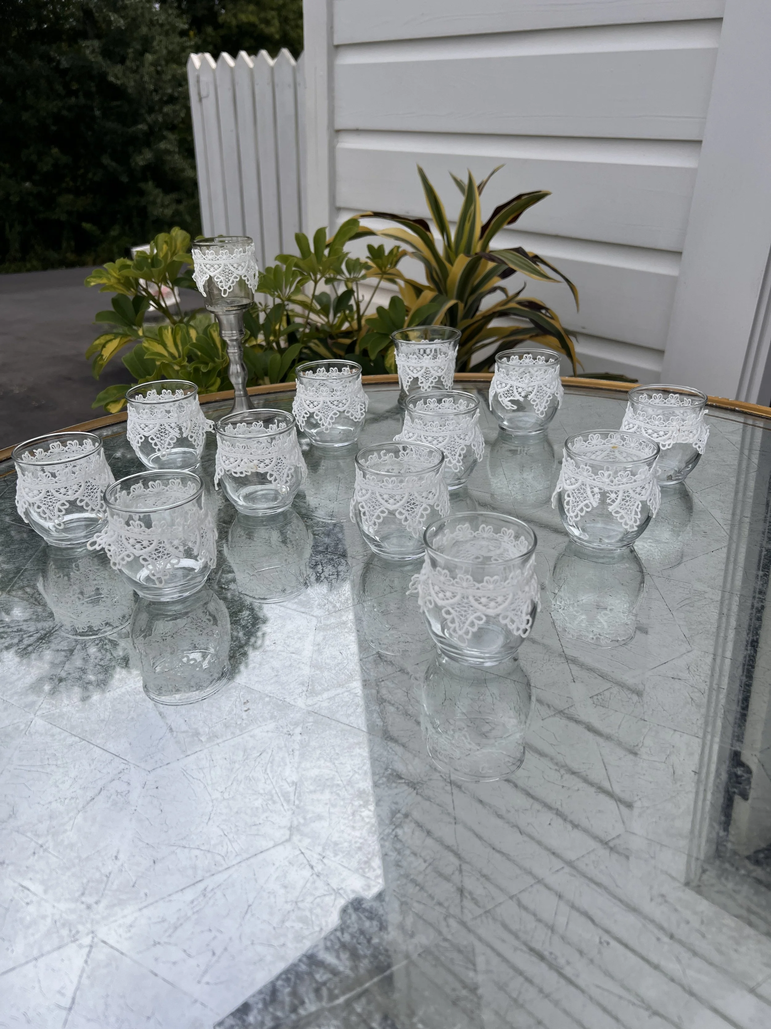 Glass votive holders with Victorian lace for wedding decorations
