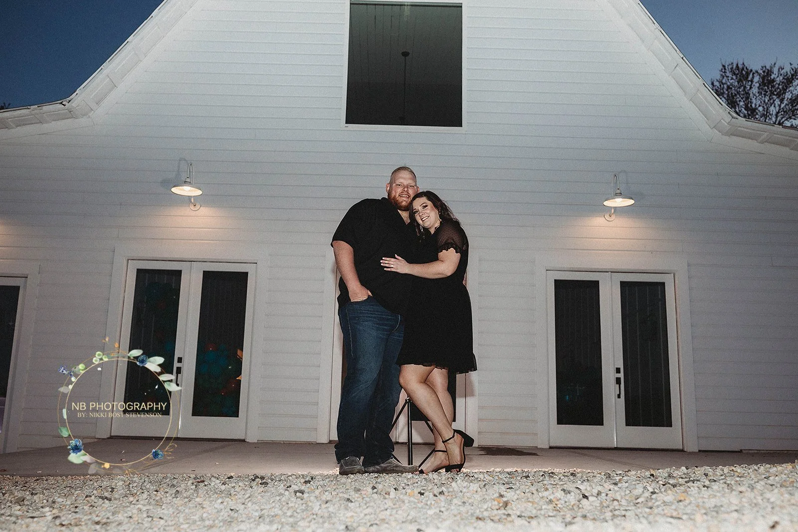 engaged couple embracing in front of white wedding venue near Charlotte NC; truth about free wedding websites