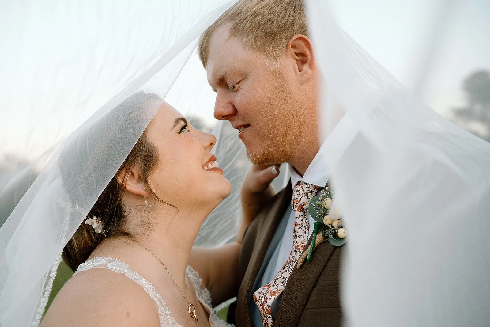 bride and groom under veil at Charlotte wedding venue
