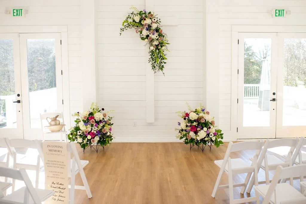 Ceremony with flowers at white Charlotte wedding venue