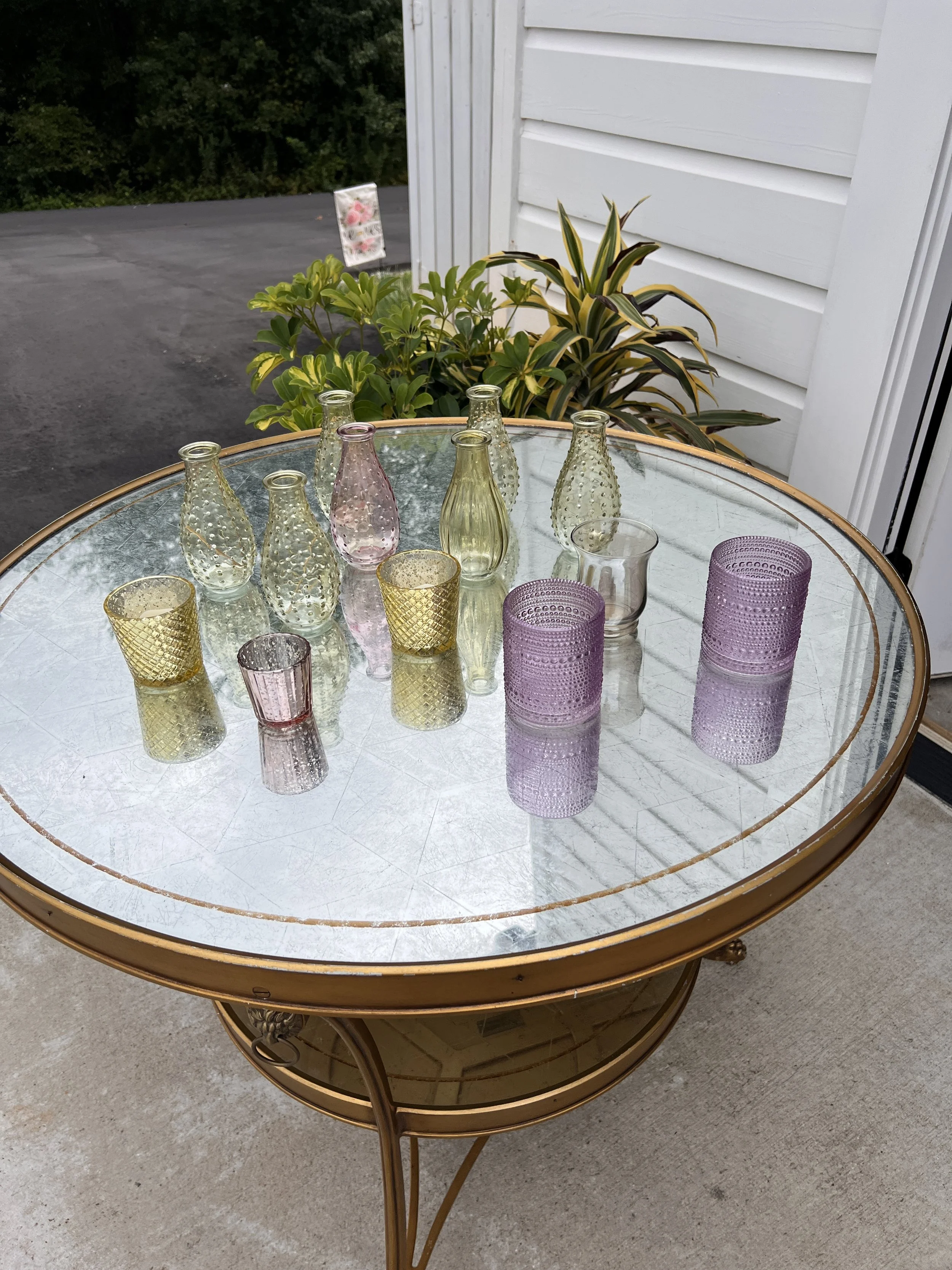 Assorted colored glass vases and votive holders for wedding decorations