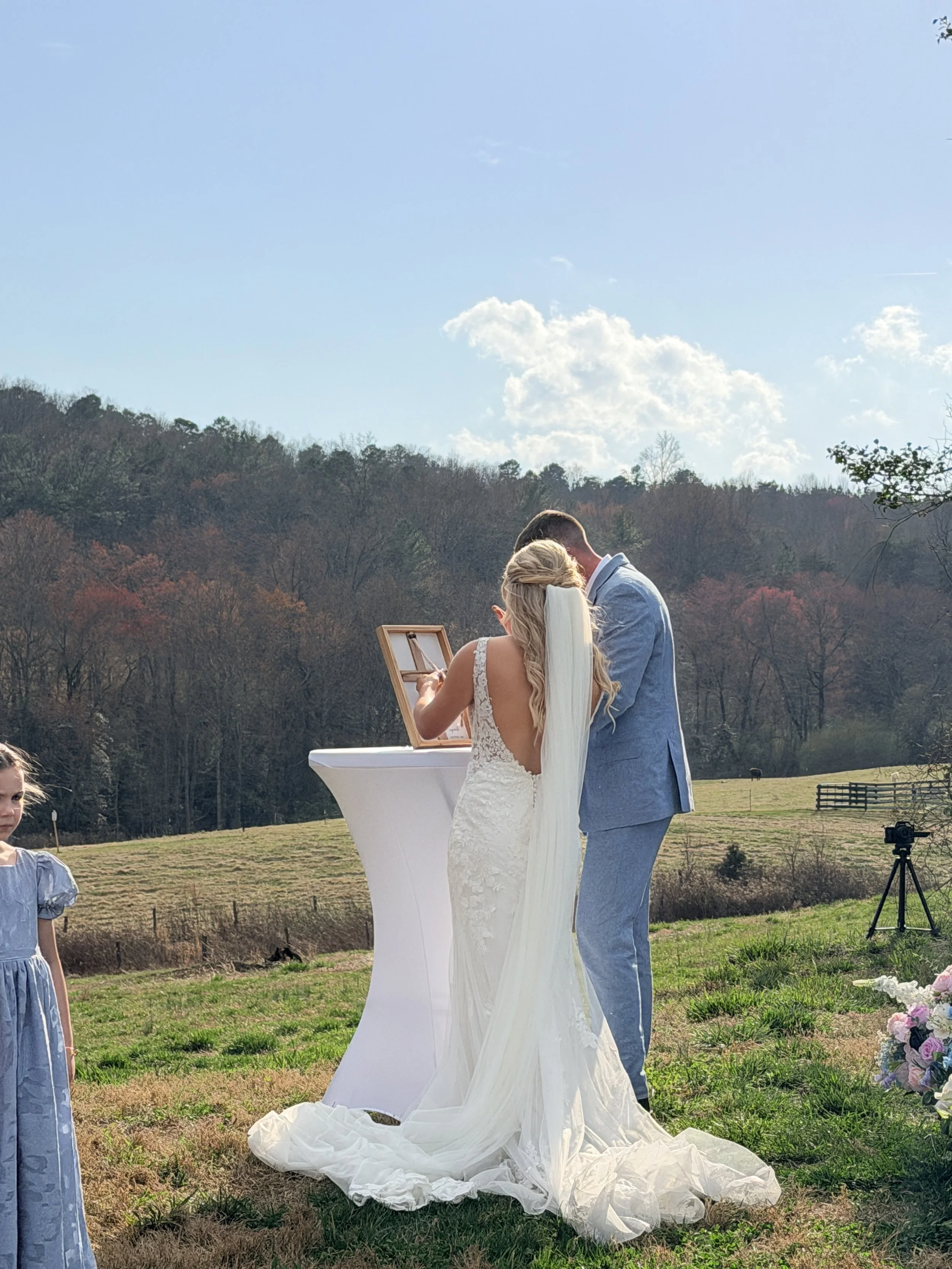 bride and groom tieing cord of three strands during outdoor wedding ceremony; the complete guide to wedding venues near Charlotte NC