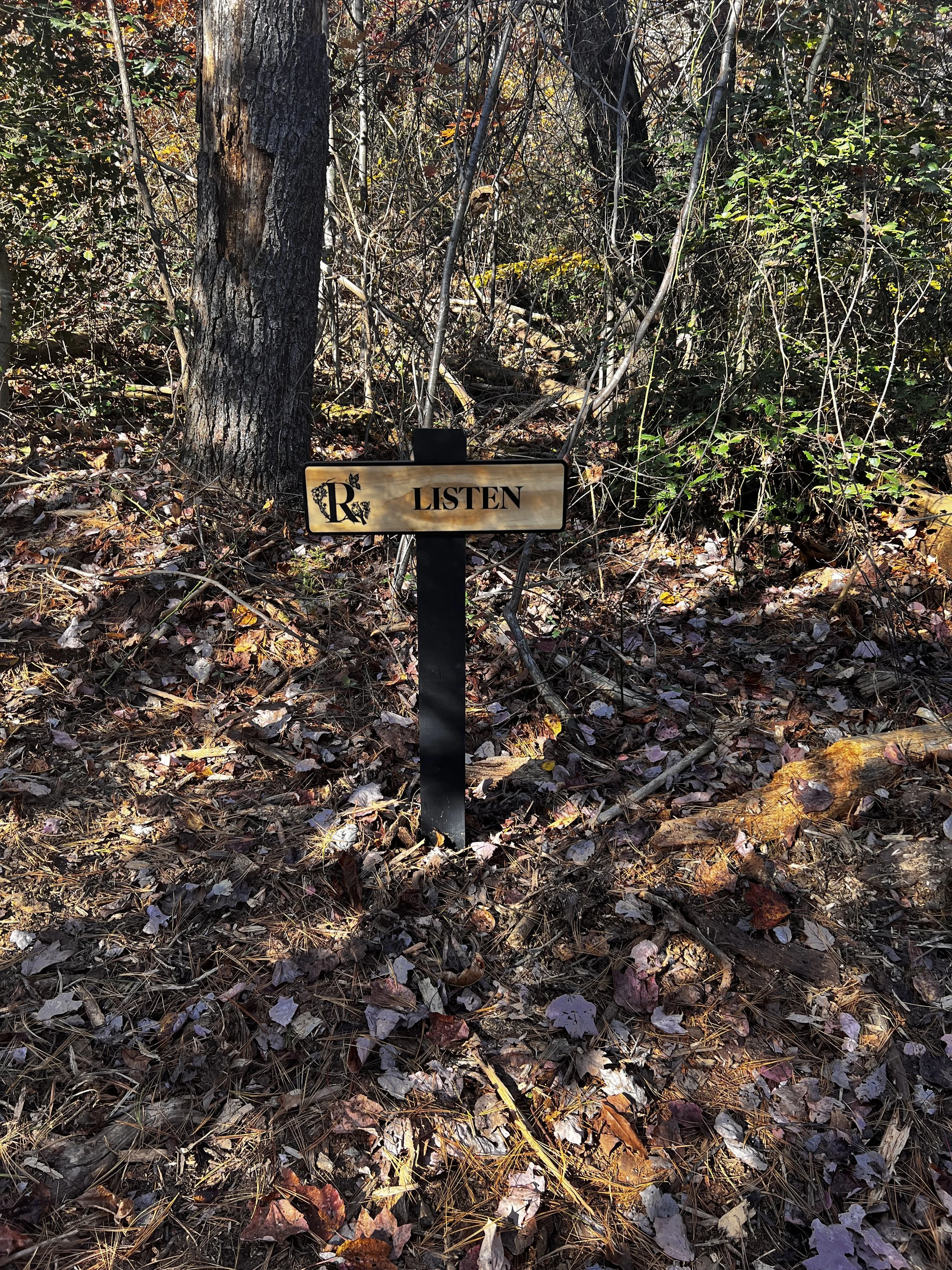 Sign that says listen in the woods; wellness retreat getaway near Charlotte