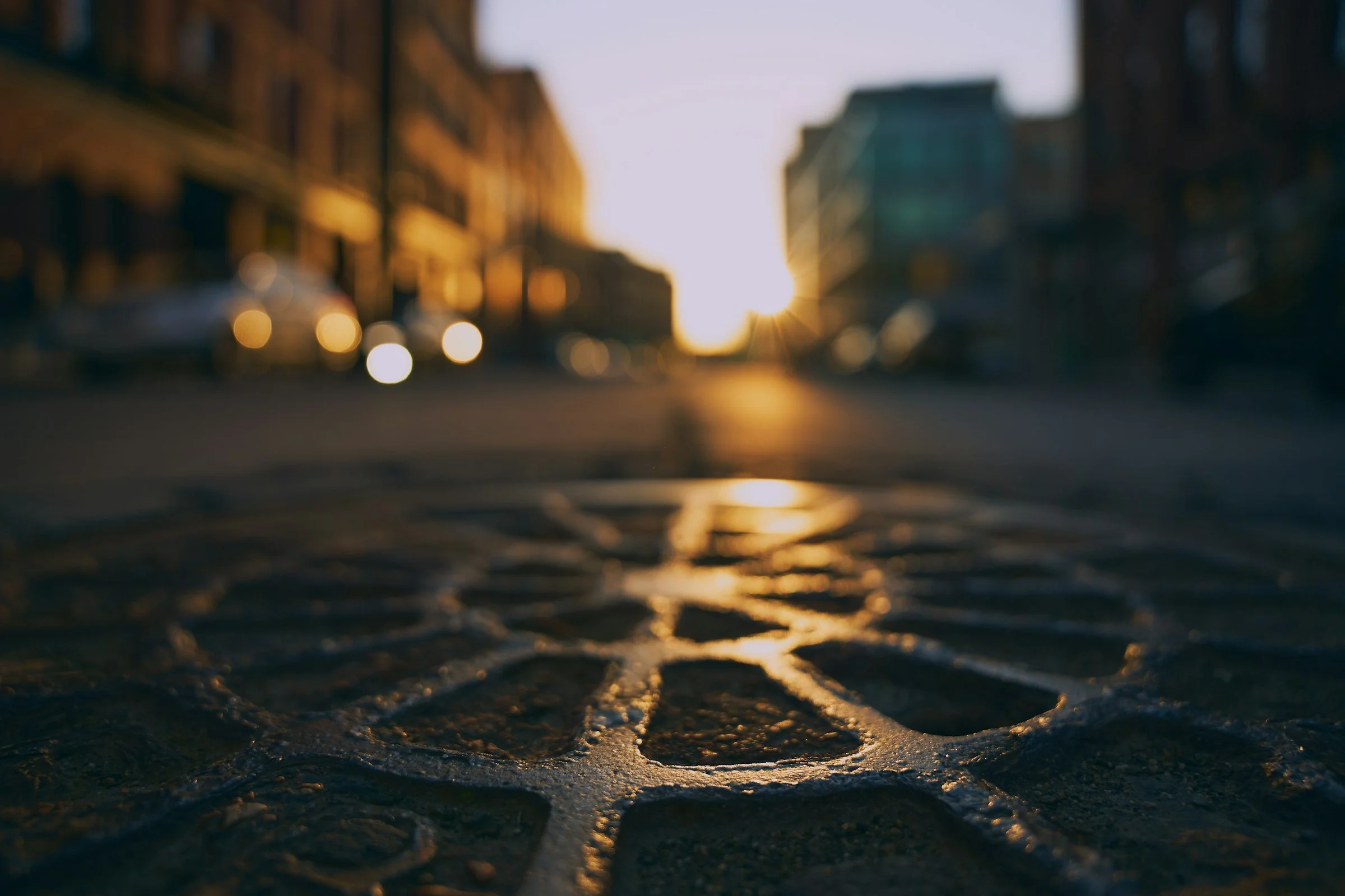 manhole cover in city at sunset