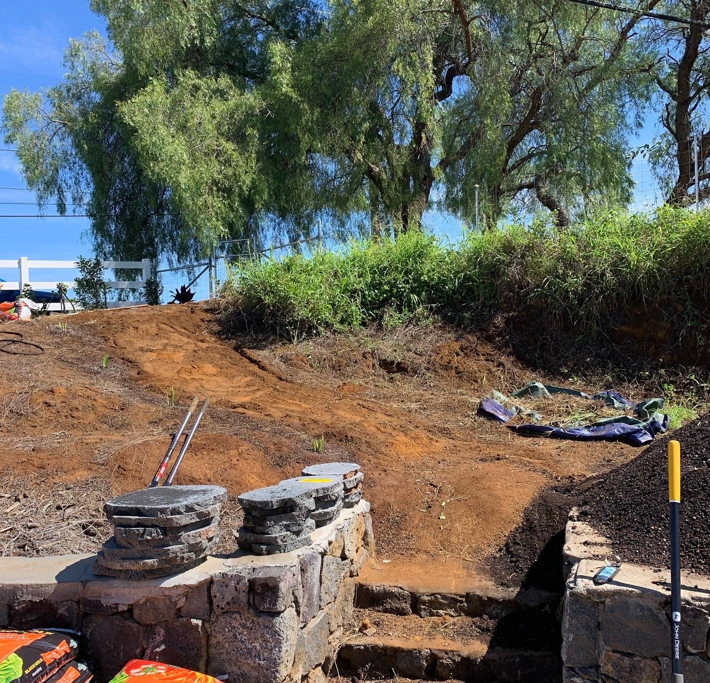 Carving the hillside to create the 40 blue rock lava paver staircase. These clients wanted it to look natural and robust, almost as if naturally created by the hill.