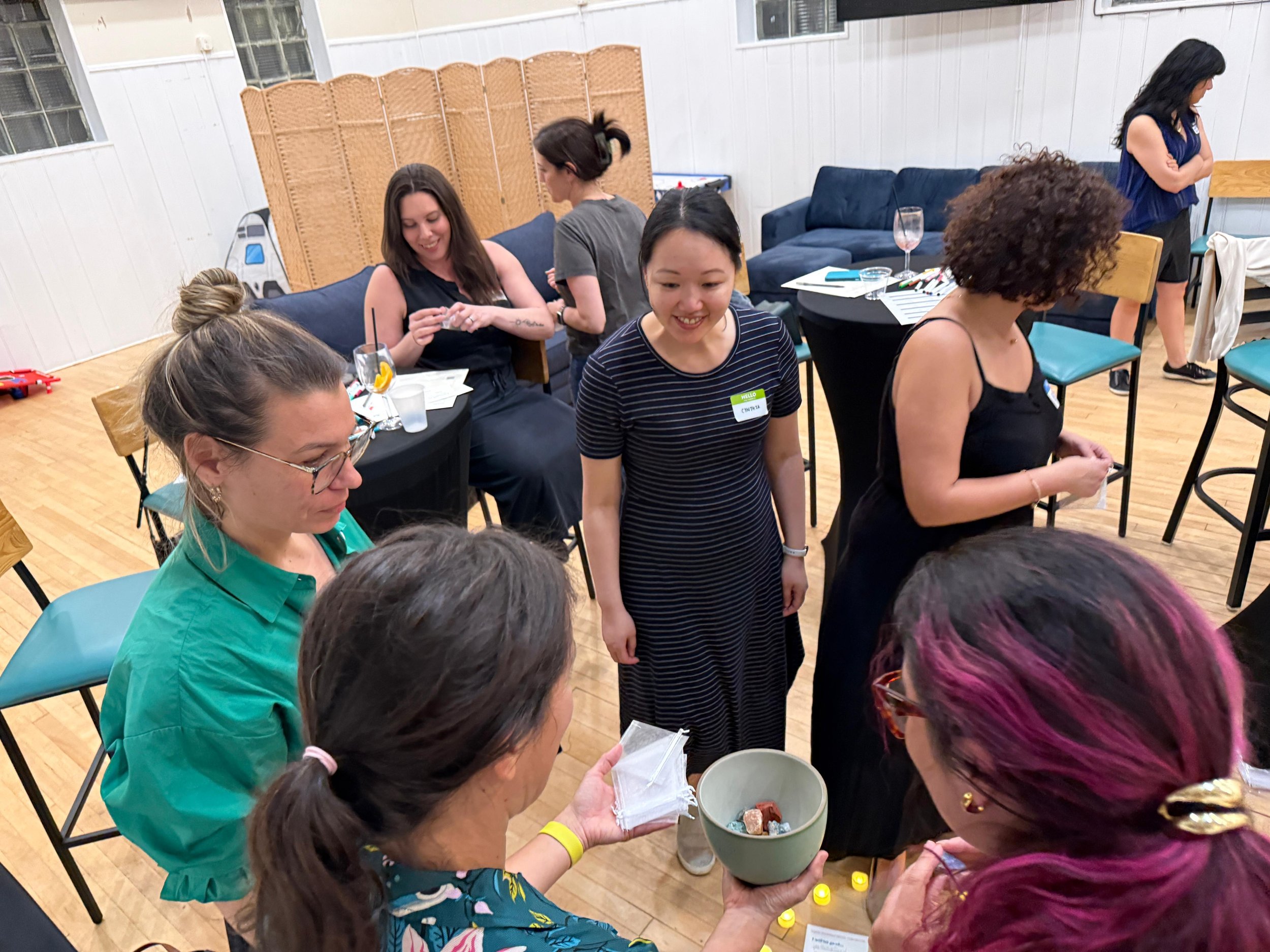 A group of local mothers interacting, sharing stories, and standing together during an evening workshop container.